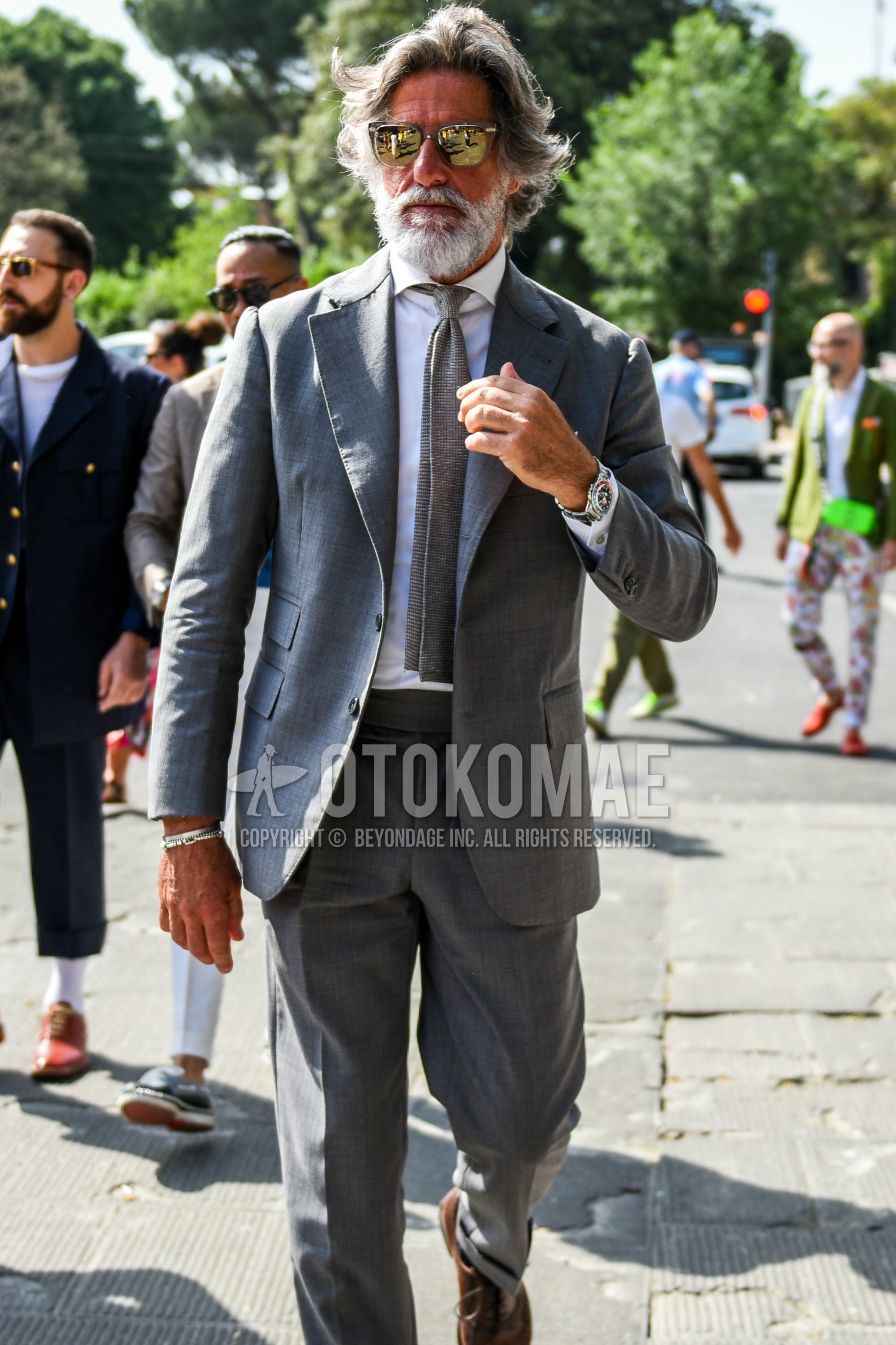 Men's spring autumn outfit with brown plain sunglasses, white plain shirt, gray plain suit, gray plain knit tie.