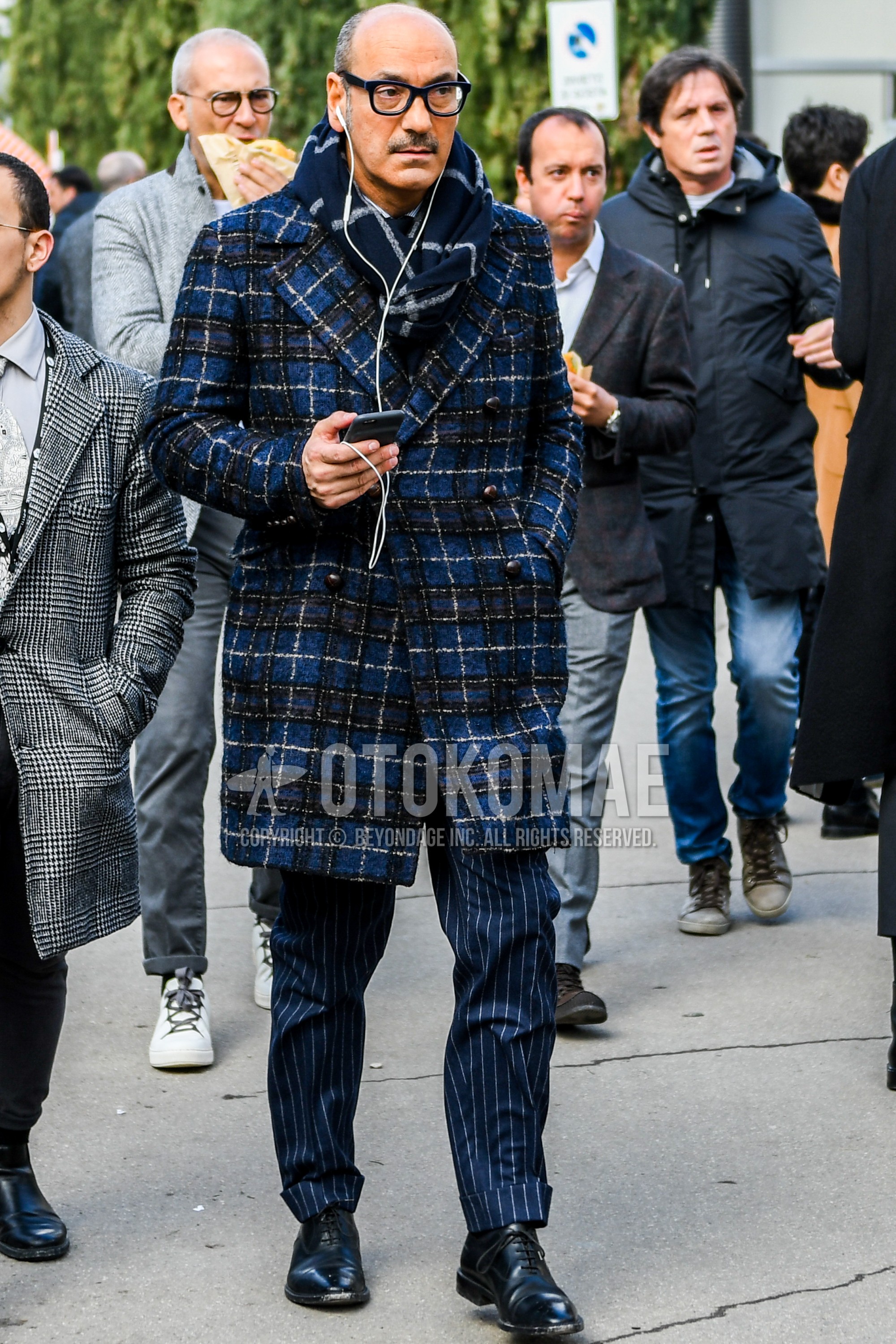 Men's autumn winter outfit with plain glasses, gray navy check scarf, navy check chester coat, navy check slacks, black straight-tip shoes leather shoes.