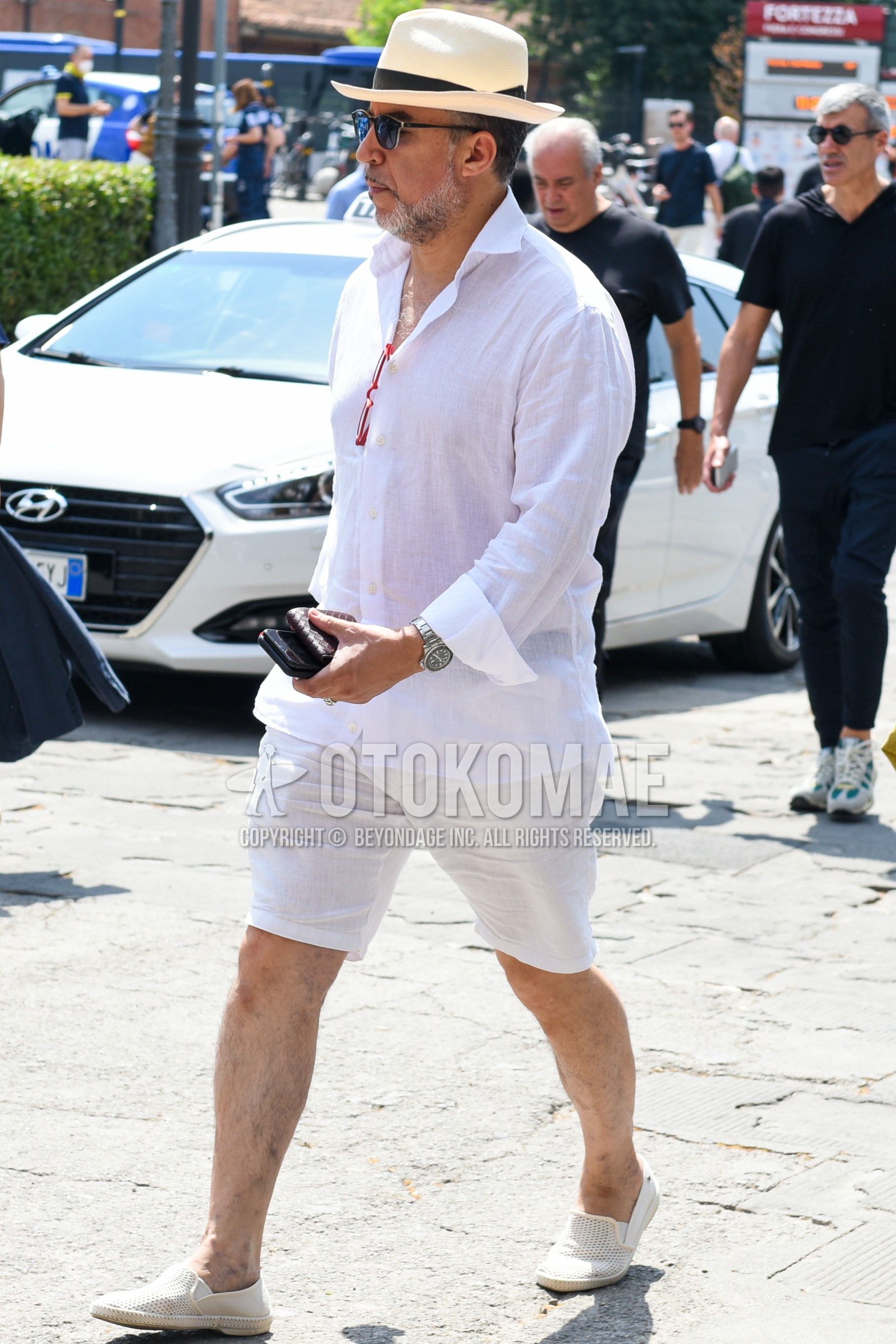 Men's summer outfit with white plain hat, black plain sunglasses, white plain shirt, white plain short pants, white slip-on sneakers.