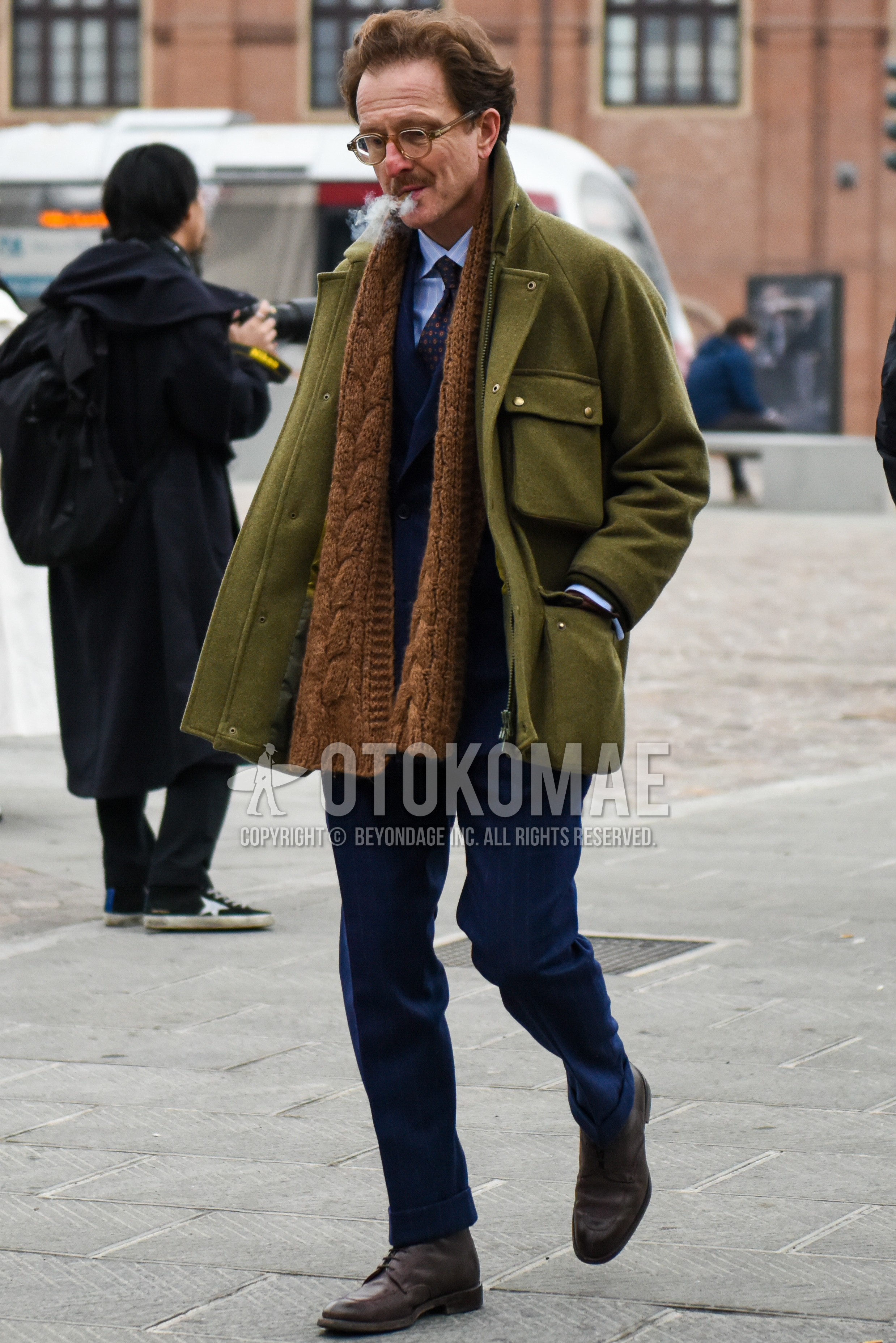 Men's winter outfit with plain glasses, brown plain scarf, olive green plain M-65, light blue plain shirt, brown u-tip shoes leather shoes, navy plain suit.