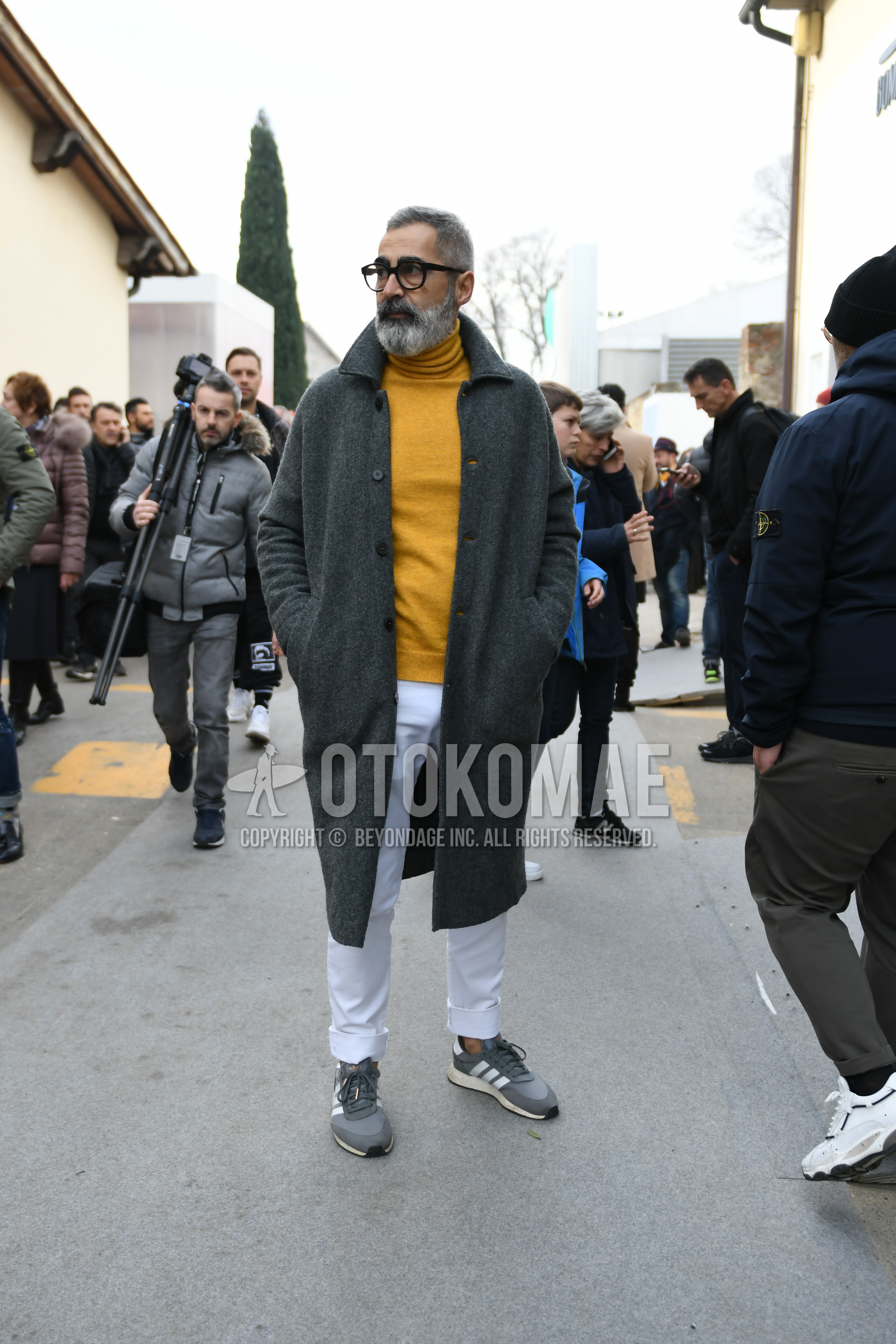 Men's autumn winter outfit with black plain glasses, gray plain stenkarrer coat, yellow plain turtleneck knit, white plain cotton pants, gray low-cut sneakers.
