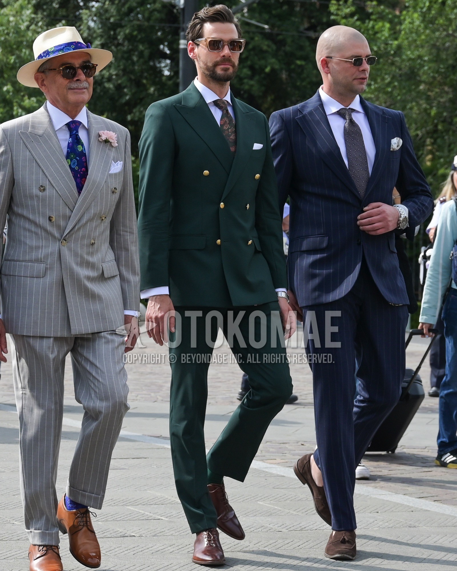 Men's spring summer autumn outfit with brown plain sunglasses, white plain shirt, brown hole cut leather shoes, green plain suit, green whole pattern necktie.
