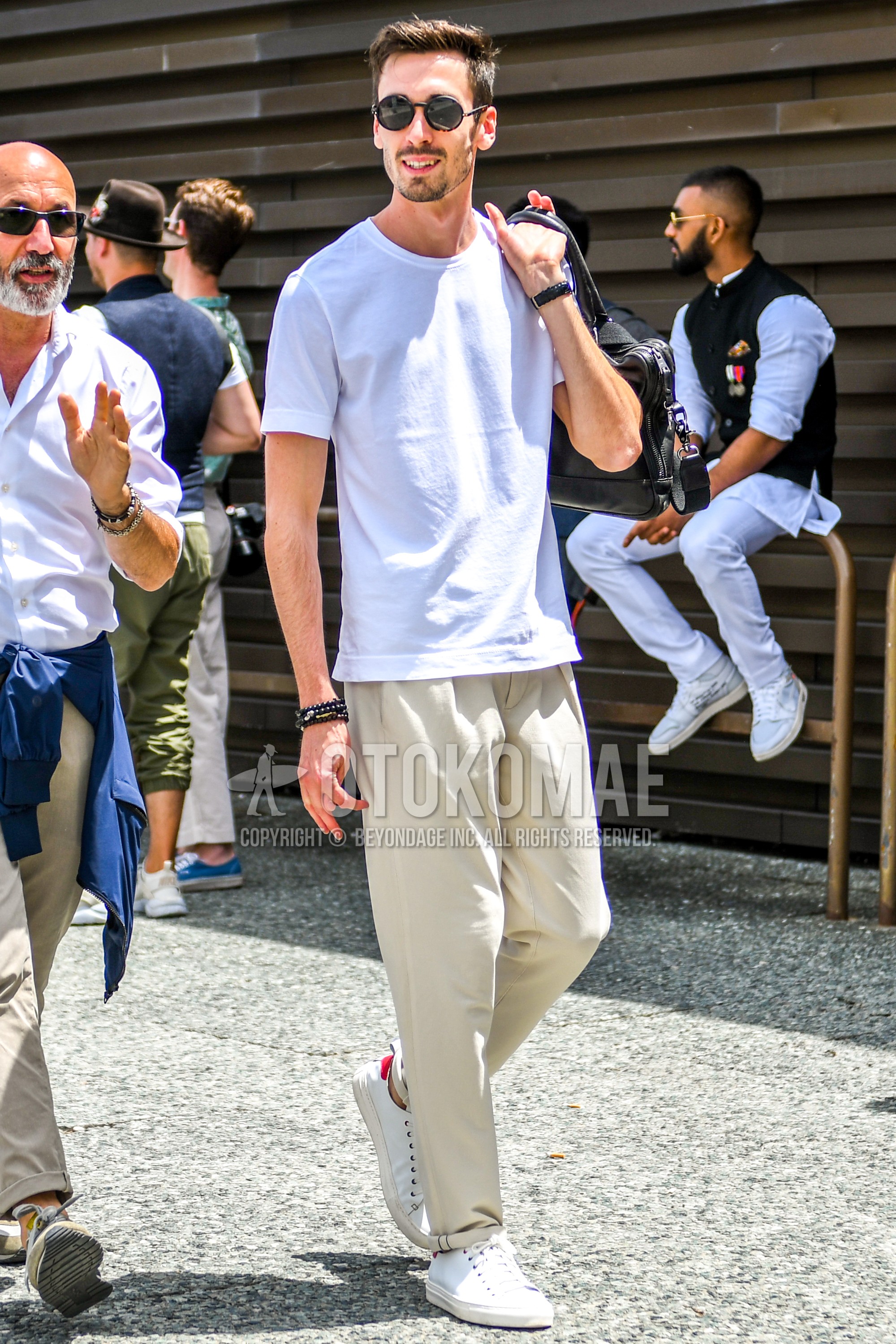 Men's summer outfit with plain sunglasses, white plain t-shirt, beige plain chinos, beige low-cut sneakers.