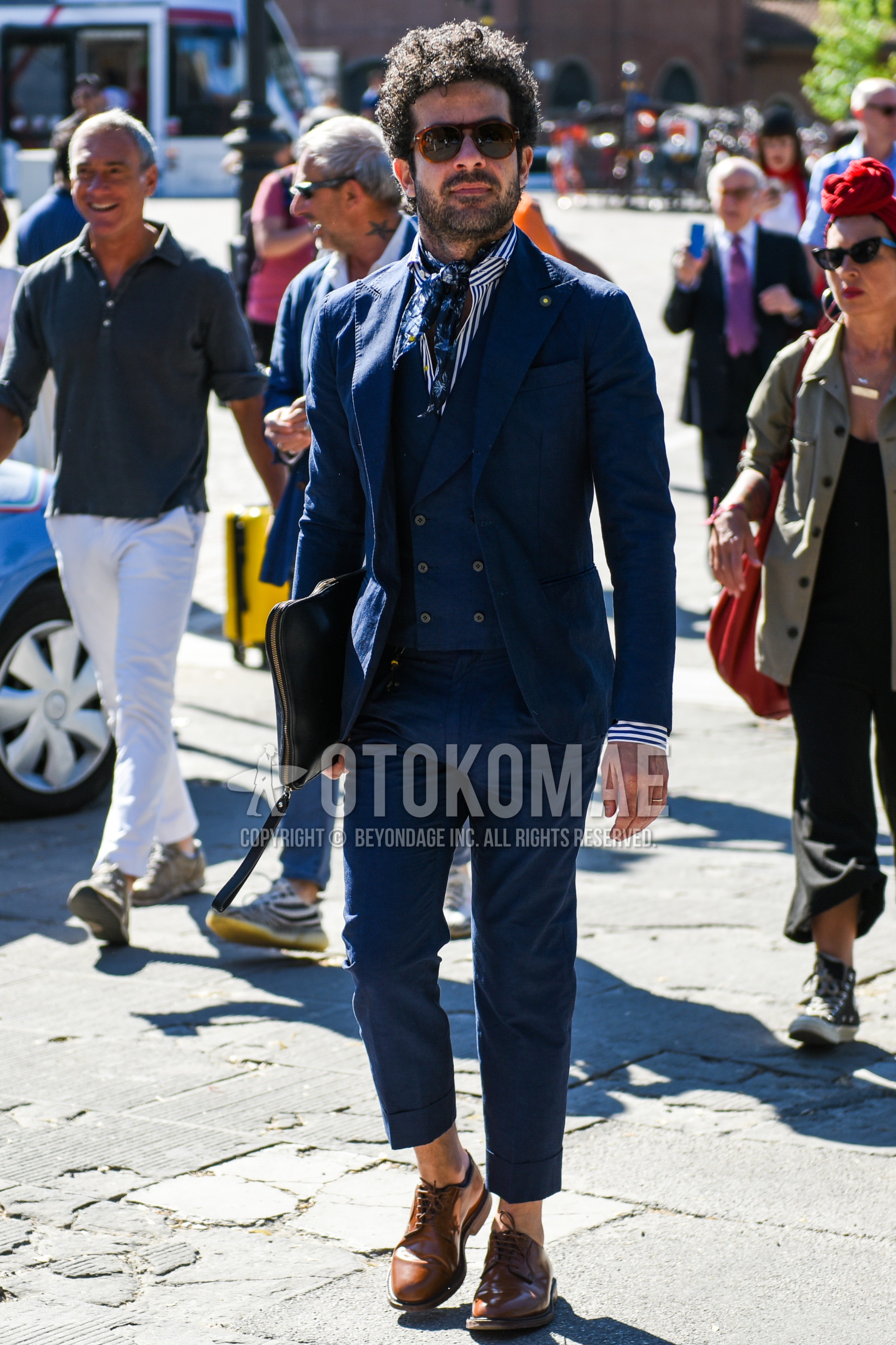 Men's spring autumn outfit with brown plain sunglasses, white blue stripes shirt, brown plain toe leather shoes, navy plain three-piece suit.