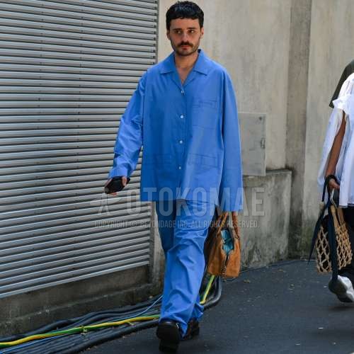 開襟　オープンカラーのブルー無地のシャツ、ブルー無地のスラックス、黒モンクシューズの革靴、レザーのベージュ無地のブリーフケース/ハンドバッグ、ブルー無地のカジュアルセットアップを合わせた春夏のメンズコーデ・着こなし。