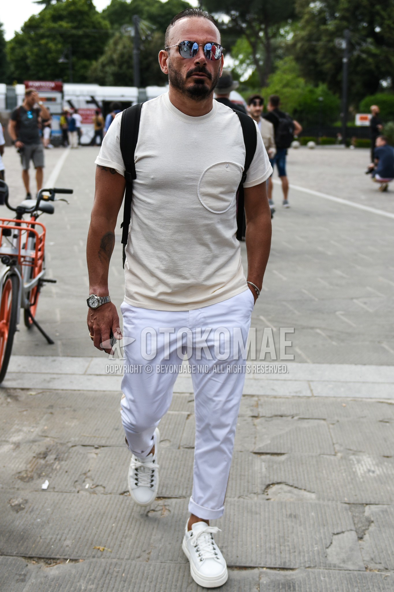 Men's summer outfit with plain sunglasses, white plain t-shirt, white plain cotton pants, white low-cut sneakers.