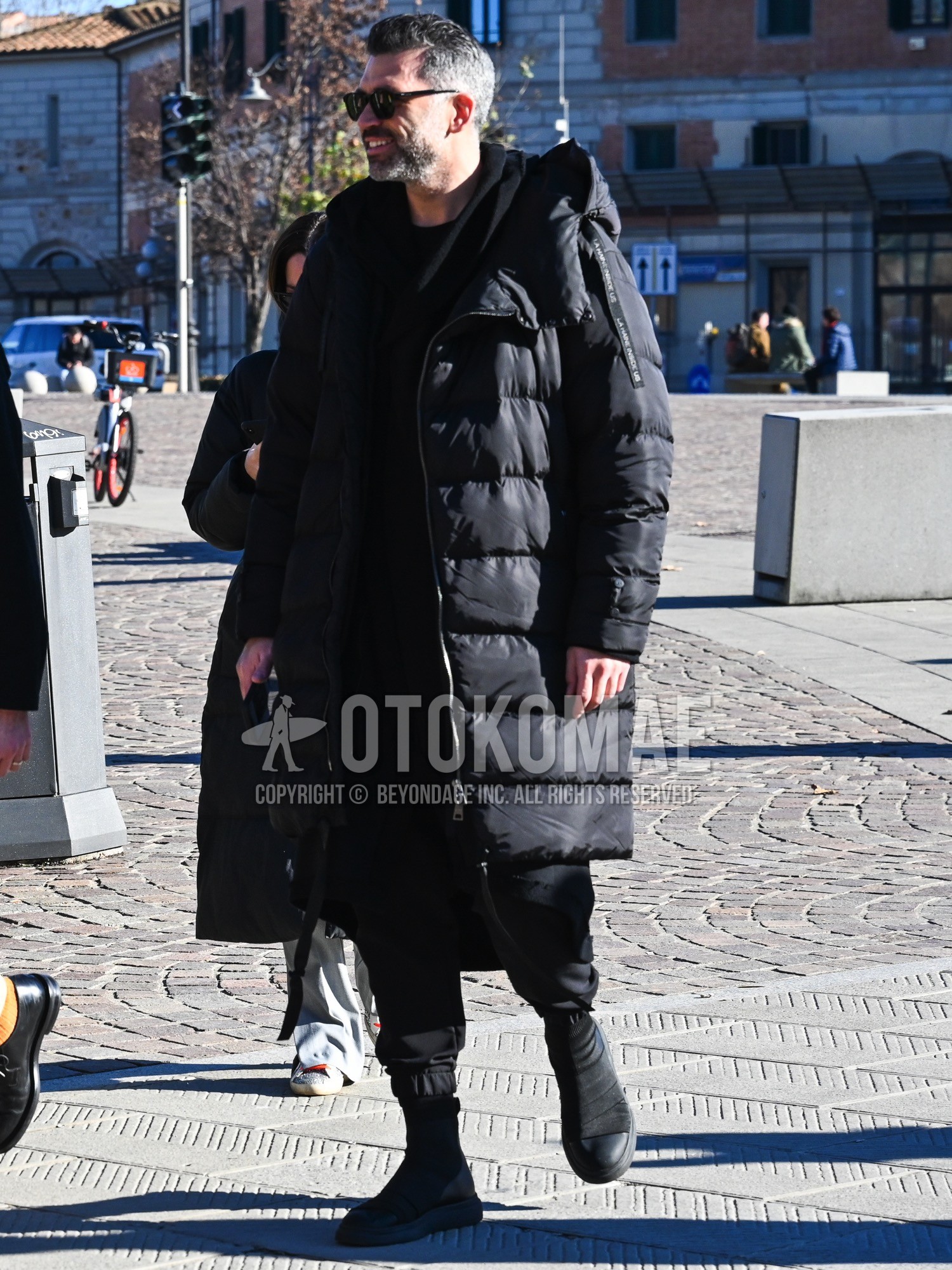 Men's autumn winter outfit with black plain sunglasses, black plain down jacket, black plain hooded coat, black plain t-shirt, black plain hoodie, black plain suluell pants, black  boots.