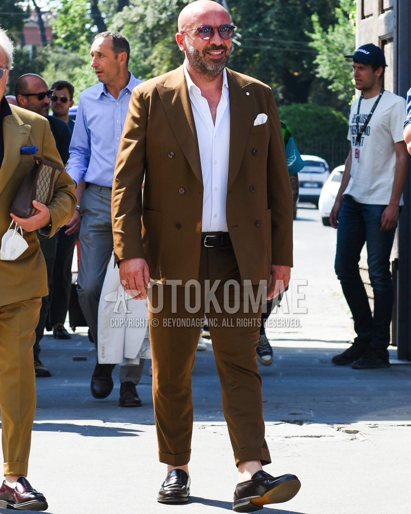 Men's spring summer outfit with red plain sunglasses, white plain shirt, plain leather belt, brown coin loafers leather shoes, brown plain suit.
