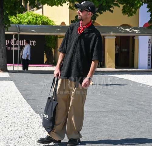 ニューエラの黒ワンポイントのベースボールキャップ、レイバン　ウェイファーラー　ウェリントンの黒無地のサングラス、レッドペイズリーのバンダナ/ネッカチーフ、開襟　オープンカラーの黒トップス/インナーのシャツ、黒ベルトのレザーベルト、ベージュ無地のチノパン、ベージュ無地のスラックス、ベージュ無地のワイドパンツ、黒チロリアンシューズの革靴、ディーゼルの黒レタードのトートバッグを合わせた夏春のメンズコーデ・着こなし。