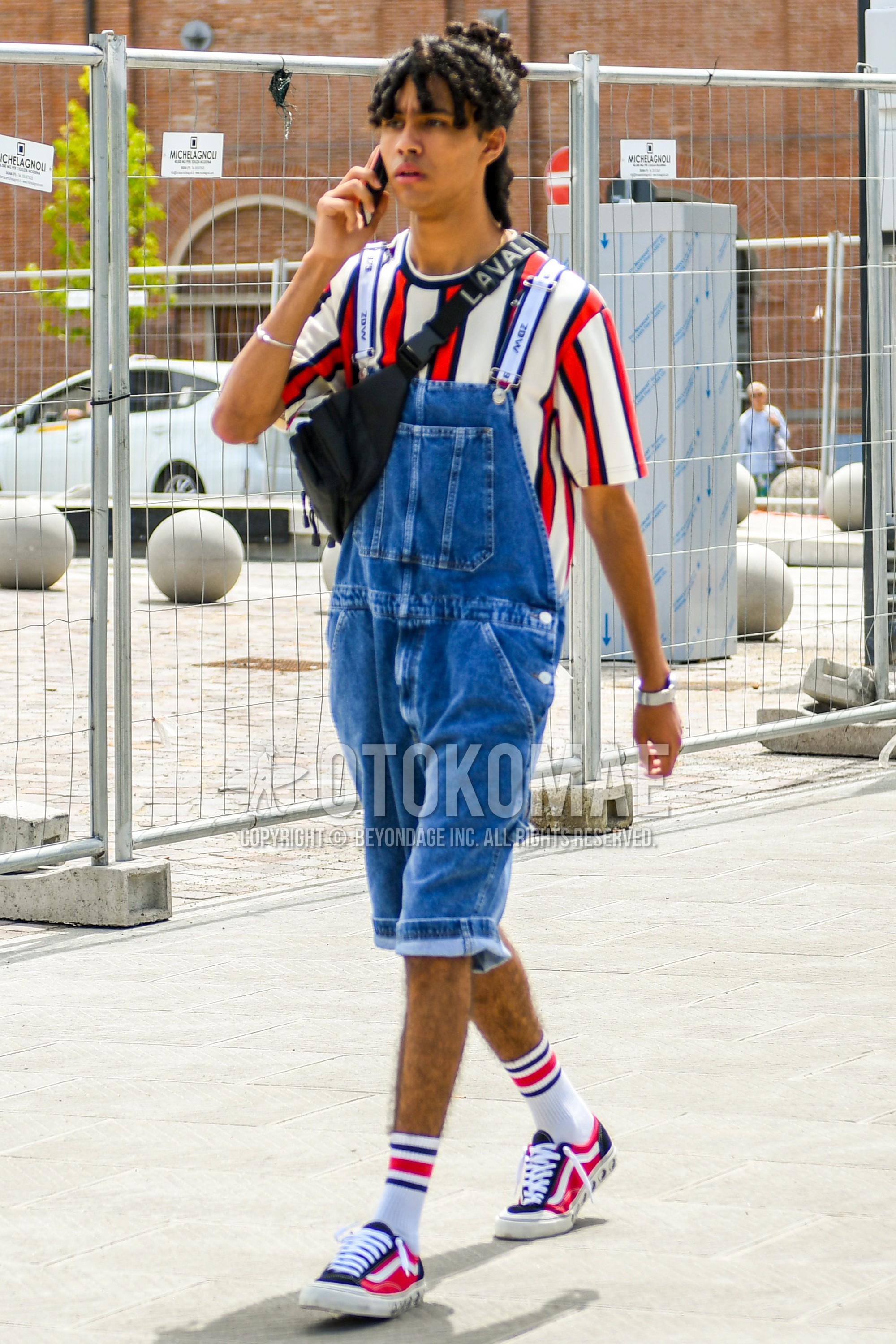 Men's summer outfit with white red stripes t-shirt, white one point suspenders, blue plain denim/jeans, white horizontal stripes socks, pink navy low-cut sneakers, black deca logo body bag.