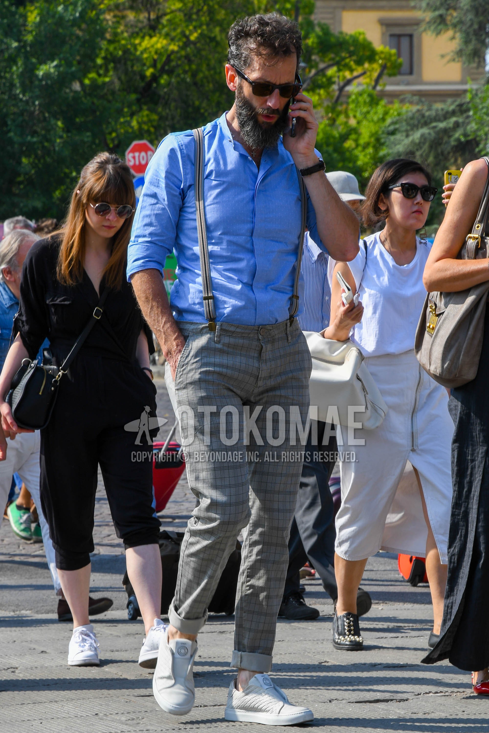 Men's spring summer outfit with brown tortoiseshell sunglasses, blue plain shirt, gray plain suspenders, gray plain slacks, white low-cut sneakers.