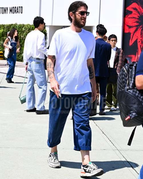 黒無地のサングラス、白無地のTシャツ、ブルー無地のスラックス、黒無地のソックス、グレーローカットのスニーカーを合わせた夏春のメンズコーデ・着こなし。