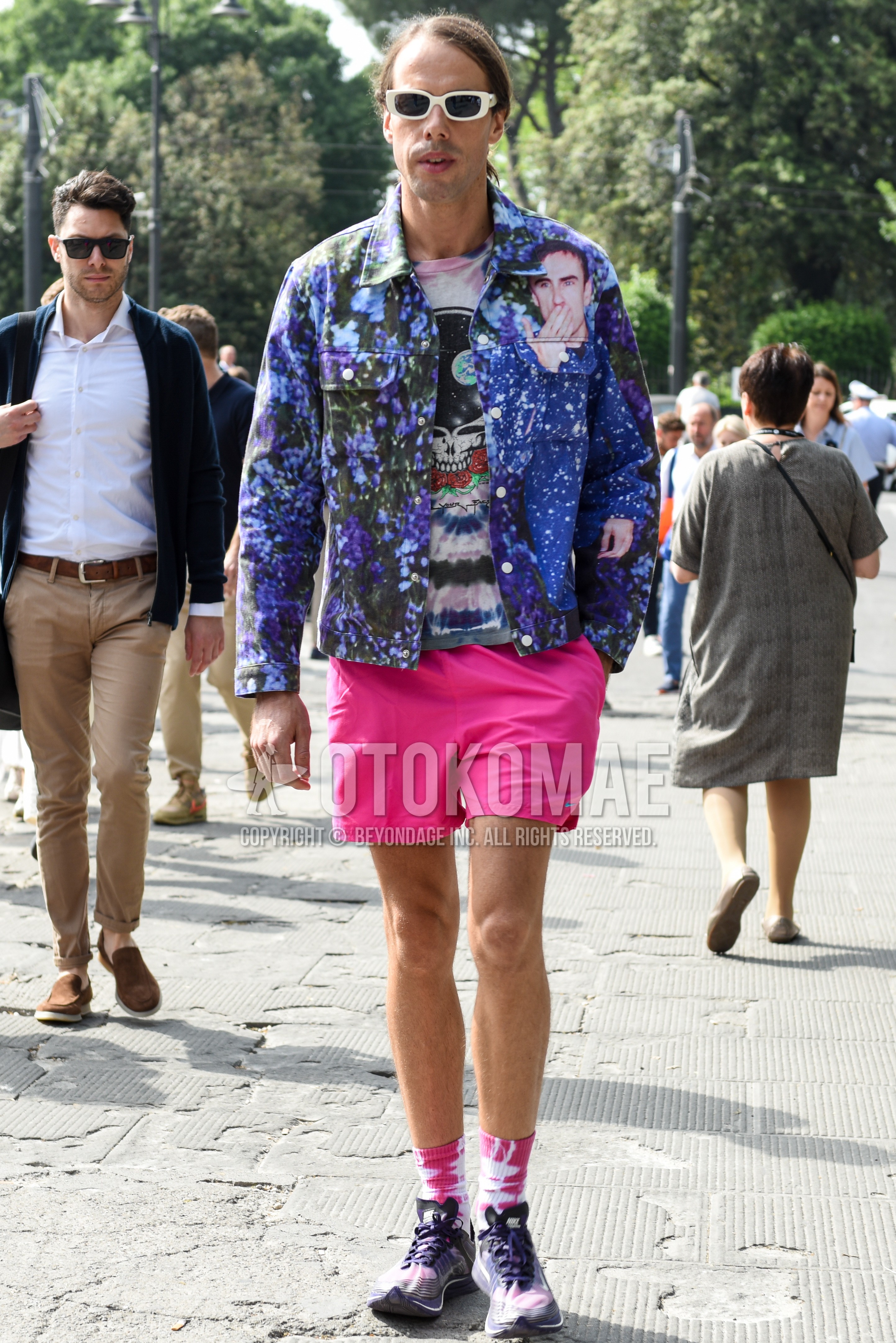 Men's spring summer autumn outfit with white plain sunglasses, blue plain trucker jacket, multi-color tops/innerwear t-shirt, pink plain short pants, pink plain socks, purple low-cut sneakers.