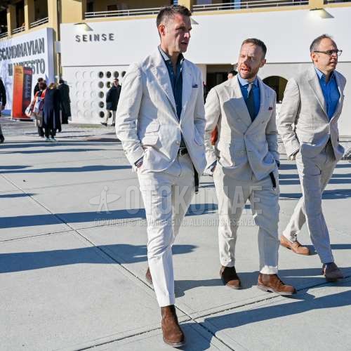 ネイビートップス/インナーのシャツ、ブラウン無地のレザーベルト、ブラウンサイドゴアのブーツ、白無地のスーツを合わせた春夏のメンズコーデ・着こなし。