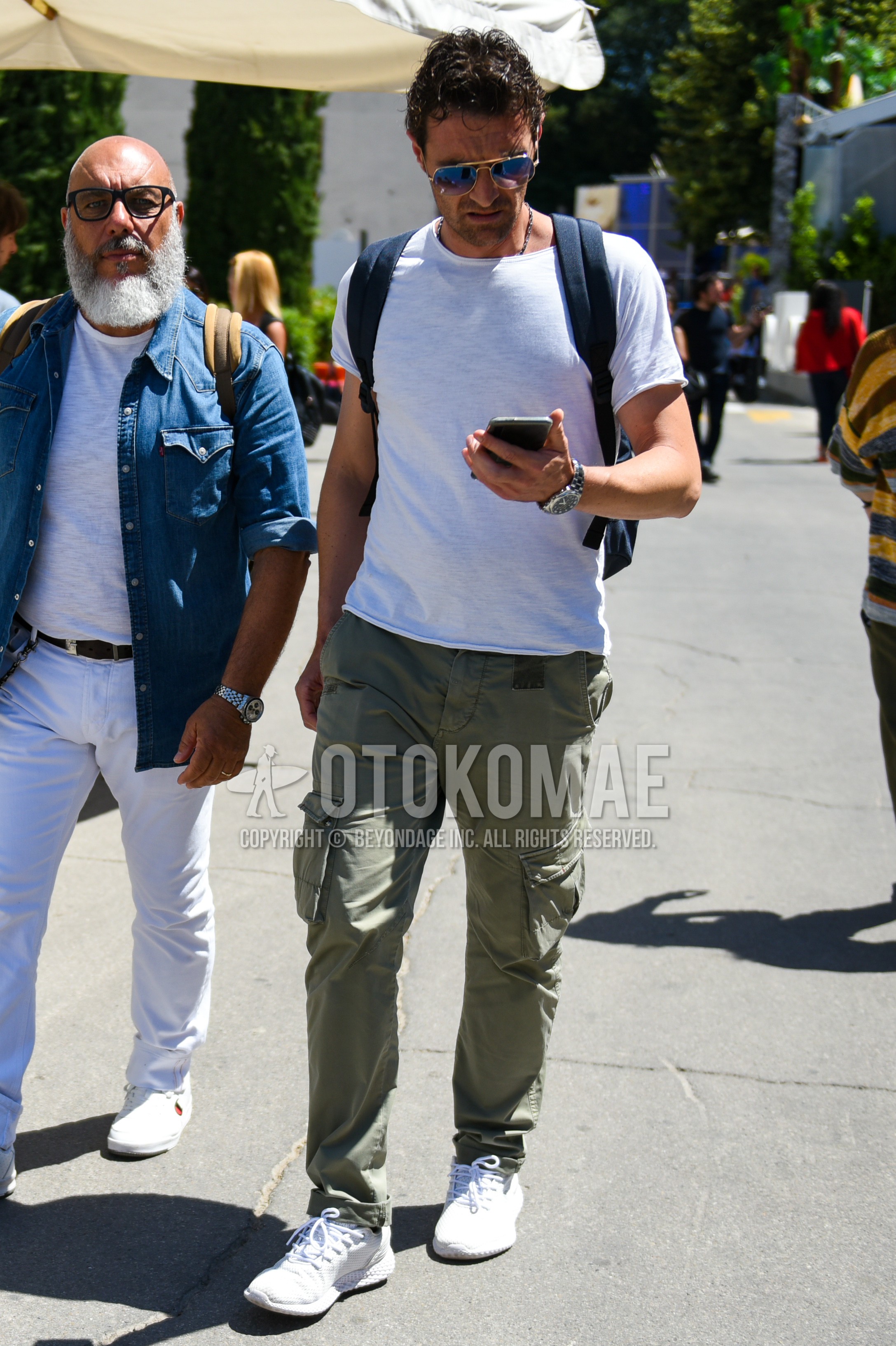 Men's summer outfit with gold plain sunglasses, white plain t-shirt, olive green plain cargo pants, white sneakers.