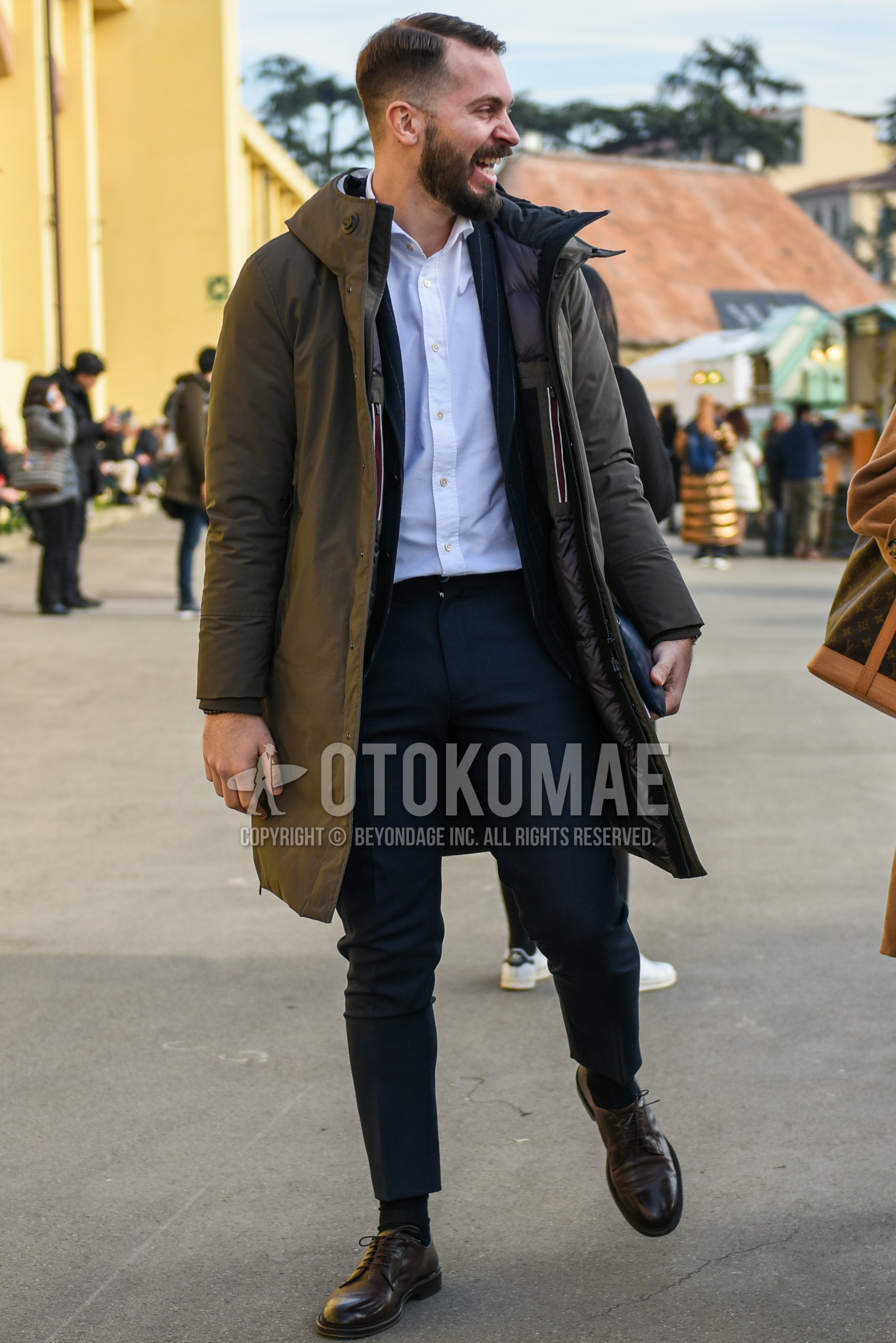 Men's winter outfit with olive green plain down jacket, olive green plain hooded coat, black stripes tailored jacket, white plain shirt, navy plain slacks, black plain socks, brown plain toe leather shoes.