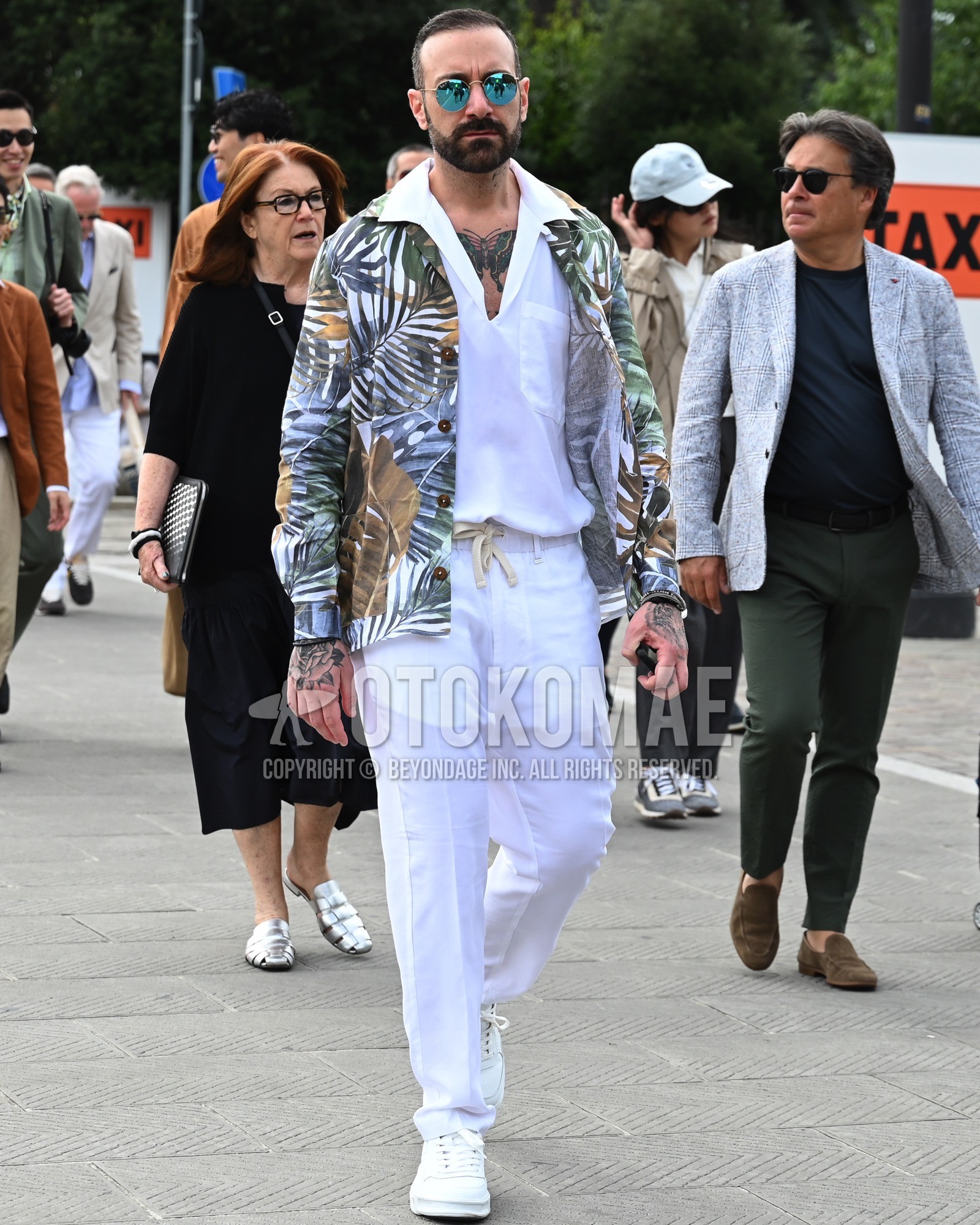 Men's spring summer autumn outfit with blue plain sunglasses, white whole pattern outerwear, white plain shirt, white plain easy pants, white low-cut sneakers.