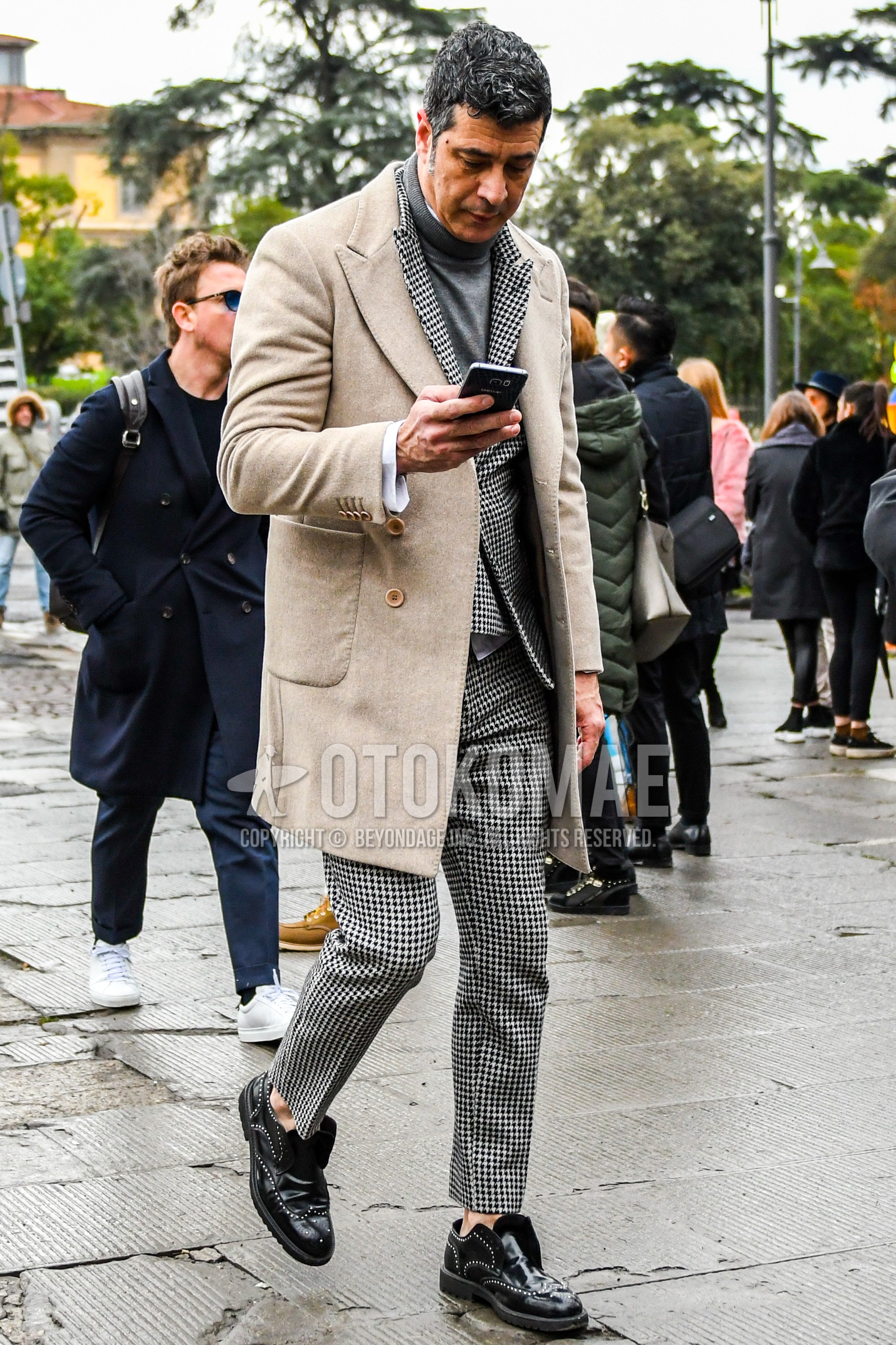 Men's winter outfit with beige plain chester coat, gray plain turtleneck knit, black brogue shoes leather shoes, gray check suit.