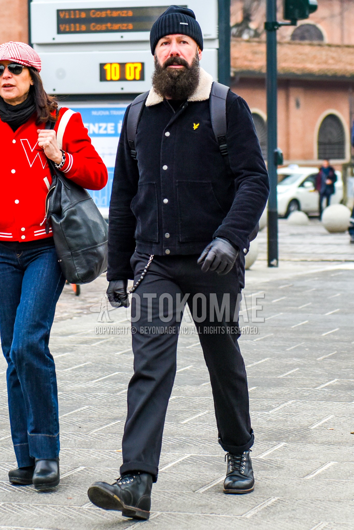 Men's winter outfit with black plain knit cap, black plain outerwear, black plain slacks, black work boots.