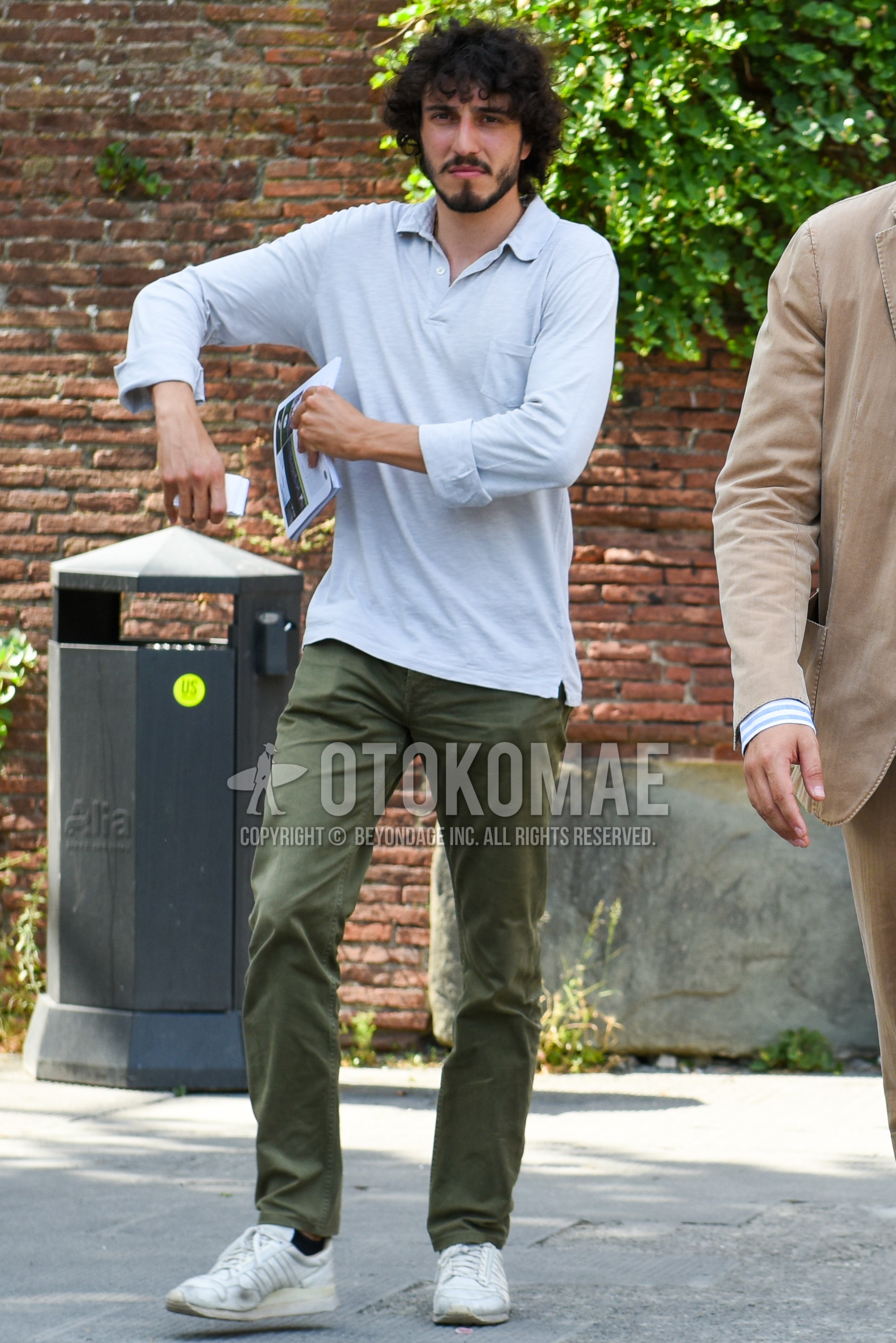 Men's spring summer outfit with gray plain polo shirt, olive green plain chinos, white sneakers.