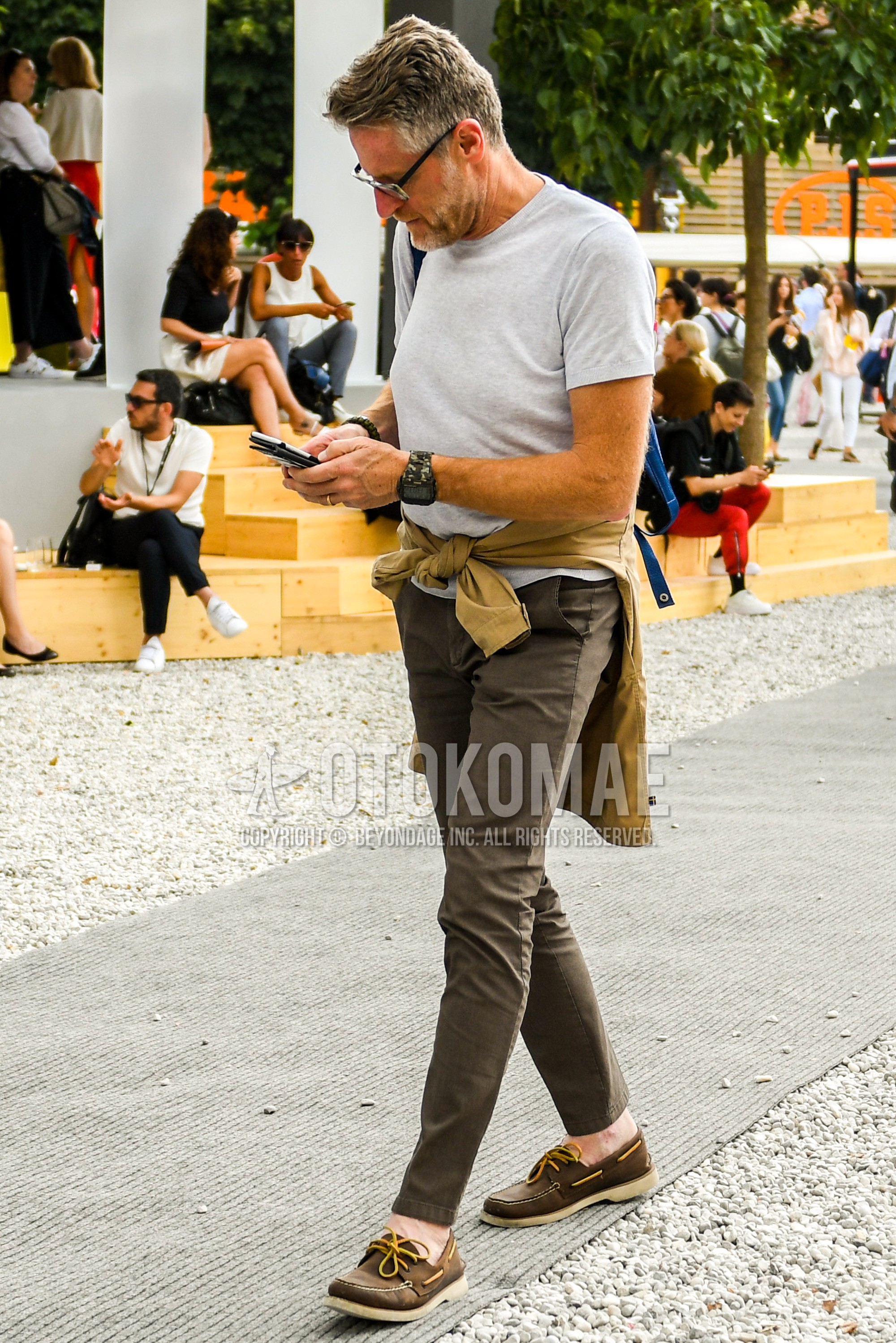 Men's summer outfit with plain glasses, gray plain t-shirt, brown plain chinos, brown moccasins/deck shoes leather shoes.
