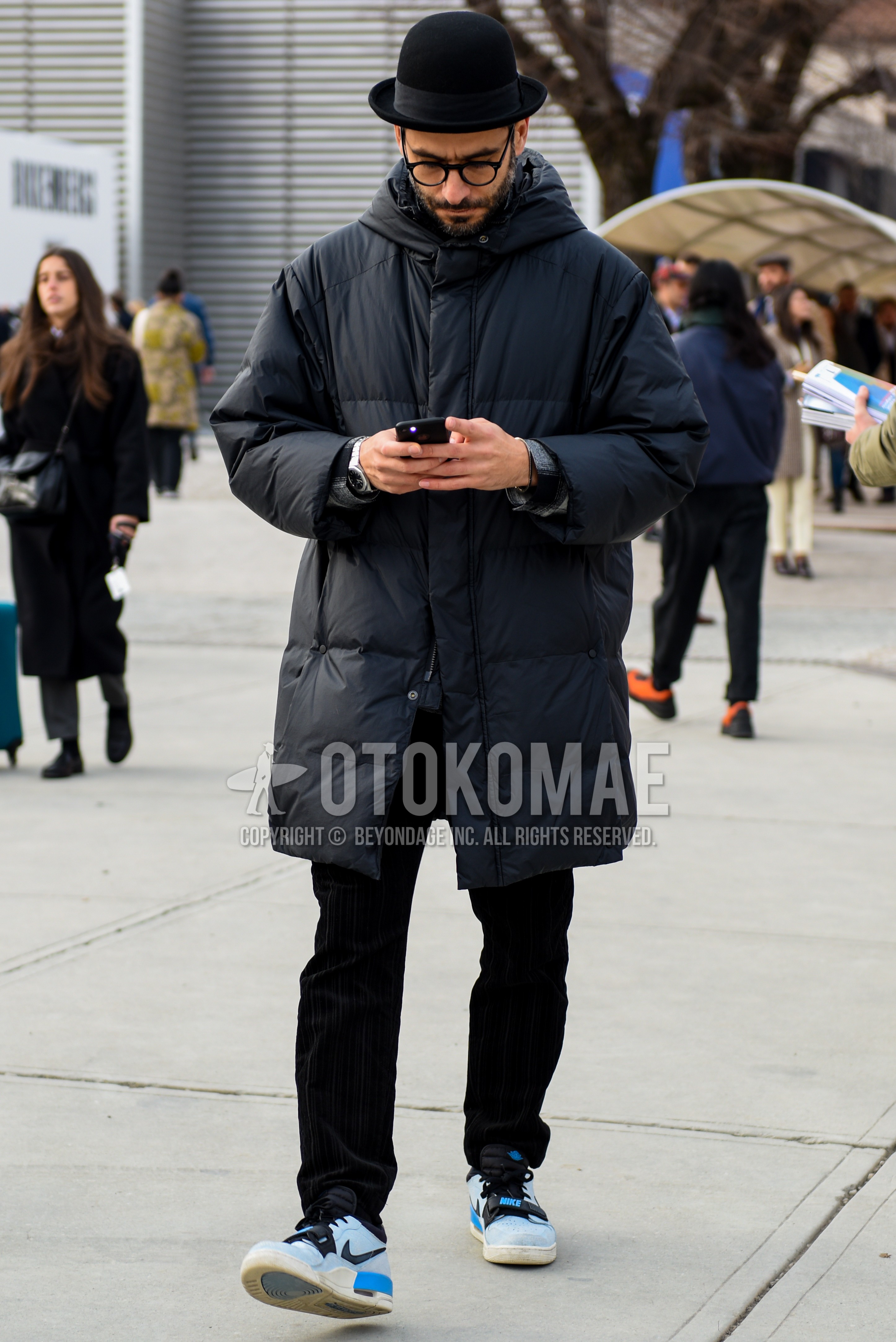 Men's autumn winter outfit with black plain hat, black plain glasses, black plain hooded coat, black plain down jacket, black plain winter pants (corduroy,velour), light blue low-cut sneakers.