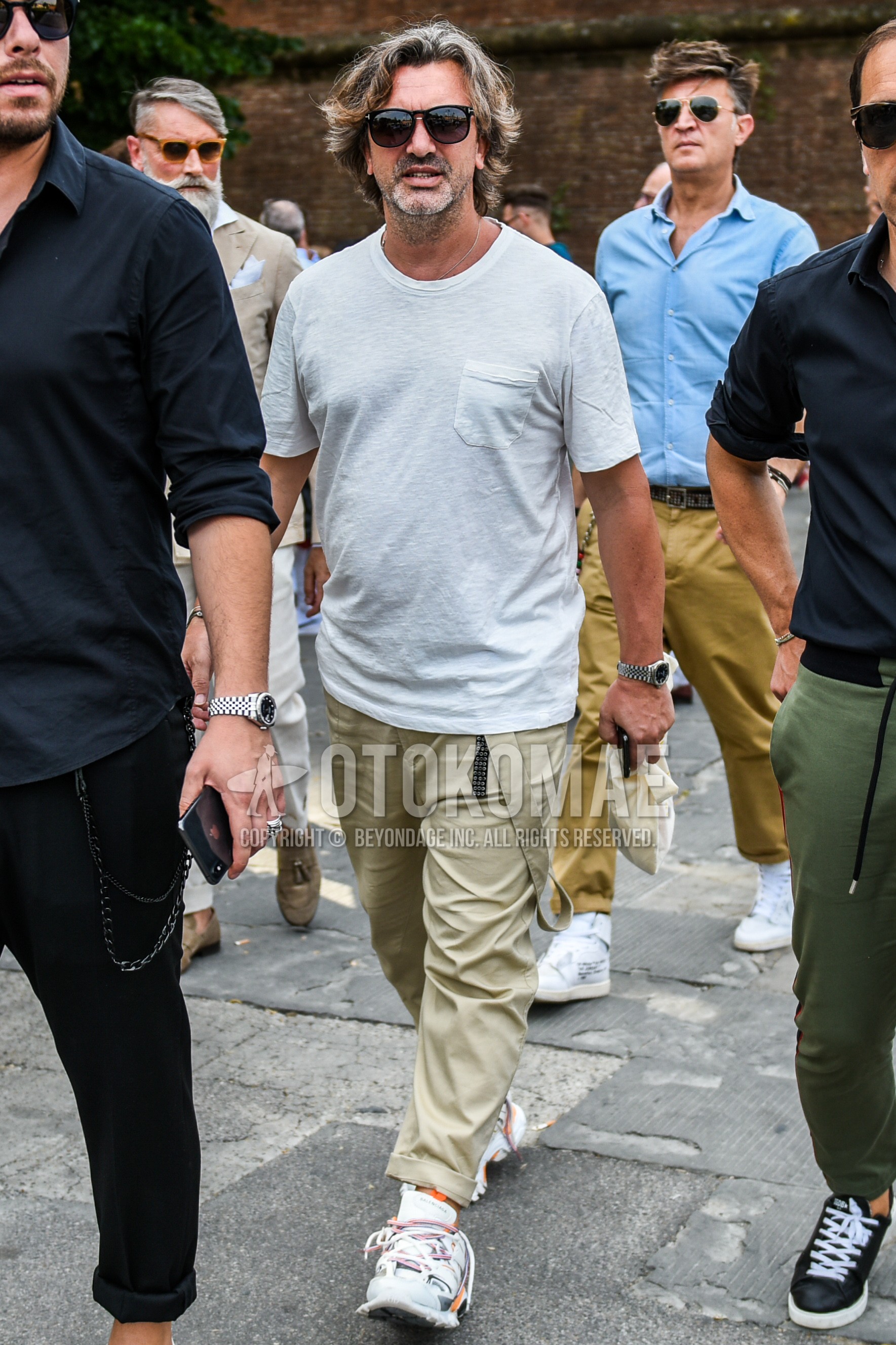 Men's summer outfit with plain sunglasses, gray plain t-shirt, beige plain cotton pants, white low-cut sneakers.