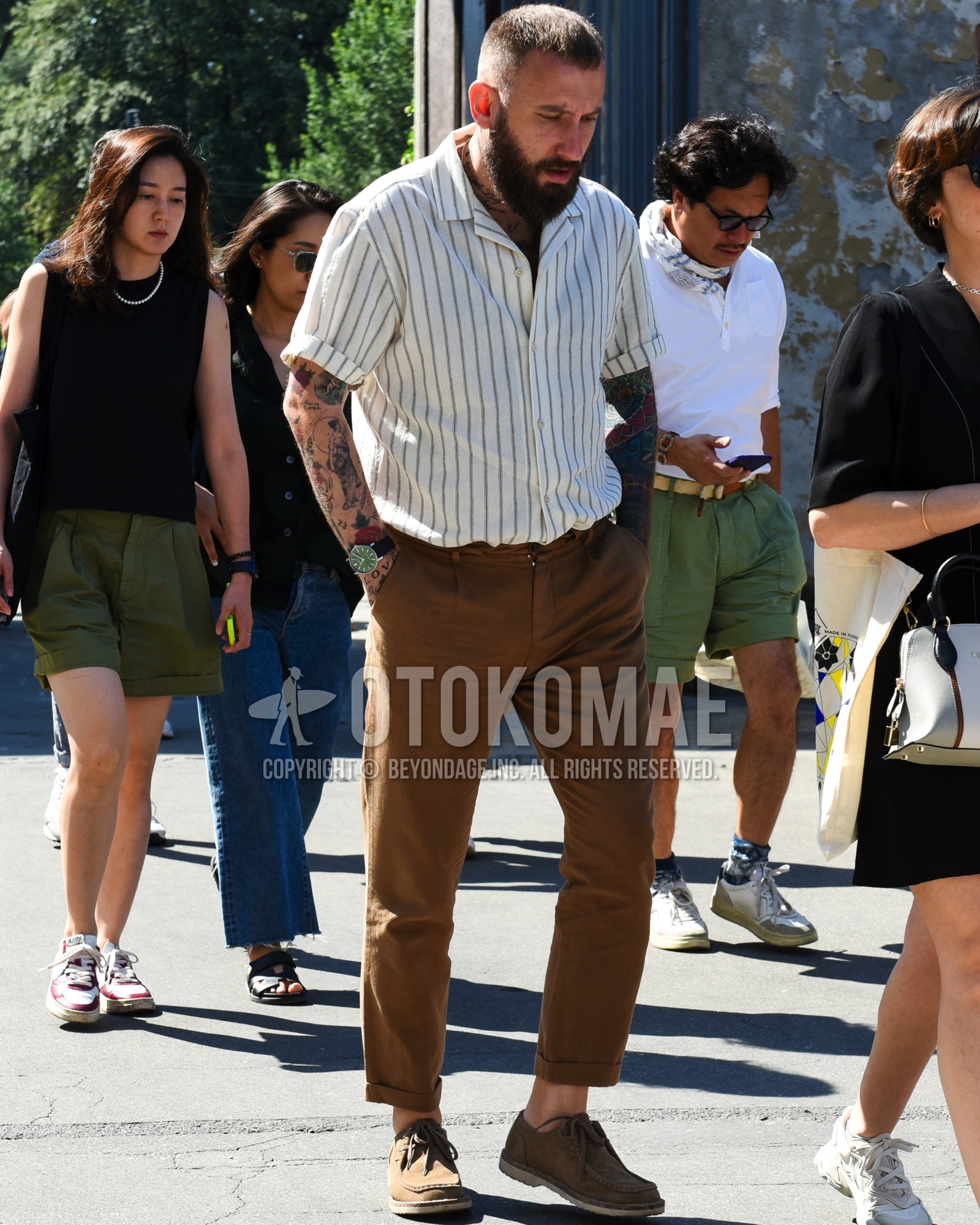 Men's spring summer outfit with beige brown stripes shirt, brown plain chinos, brown moccasins/deck shoes leather shoes.