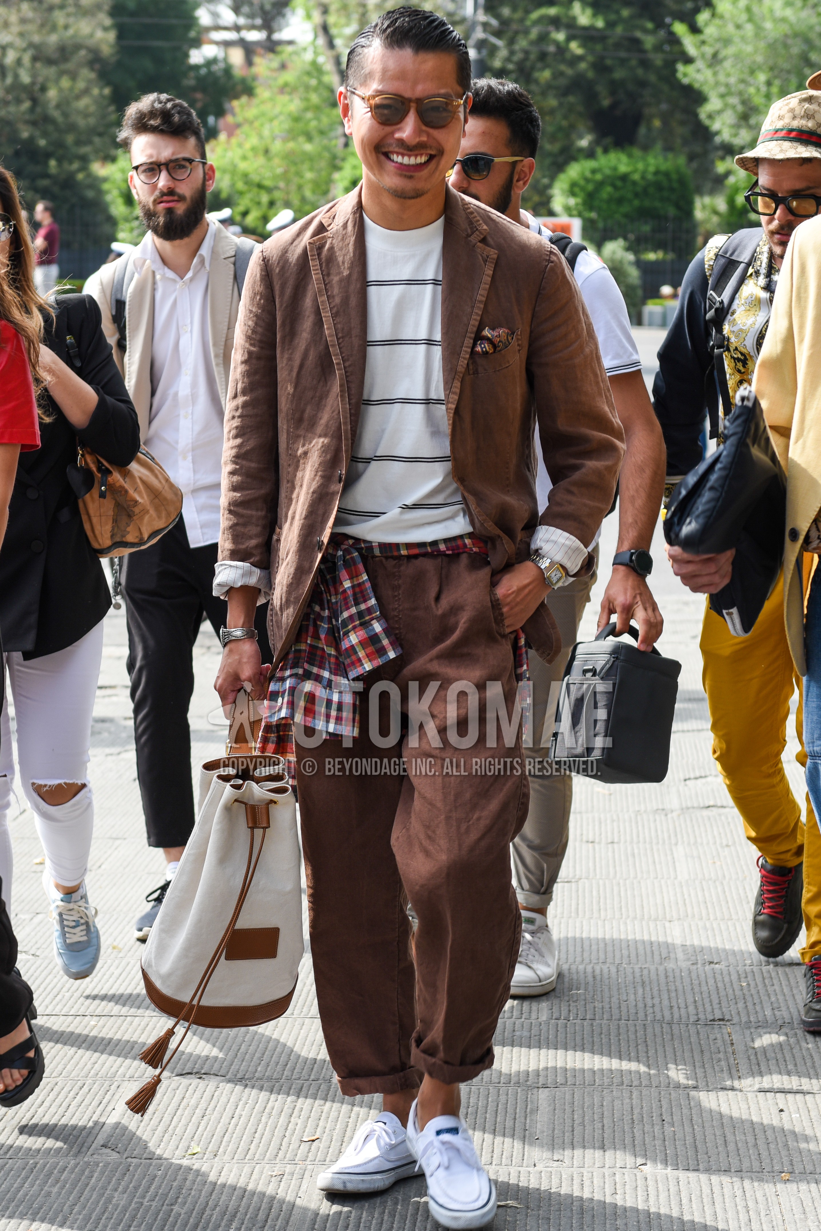 Men's spring summer autumn outfit with brown plain sunglasses, white horizontal stripes t-shirt, white low-cut sneakers, white plain bag, brown plain suit.