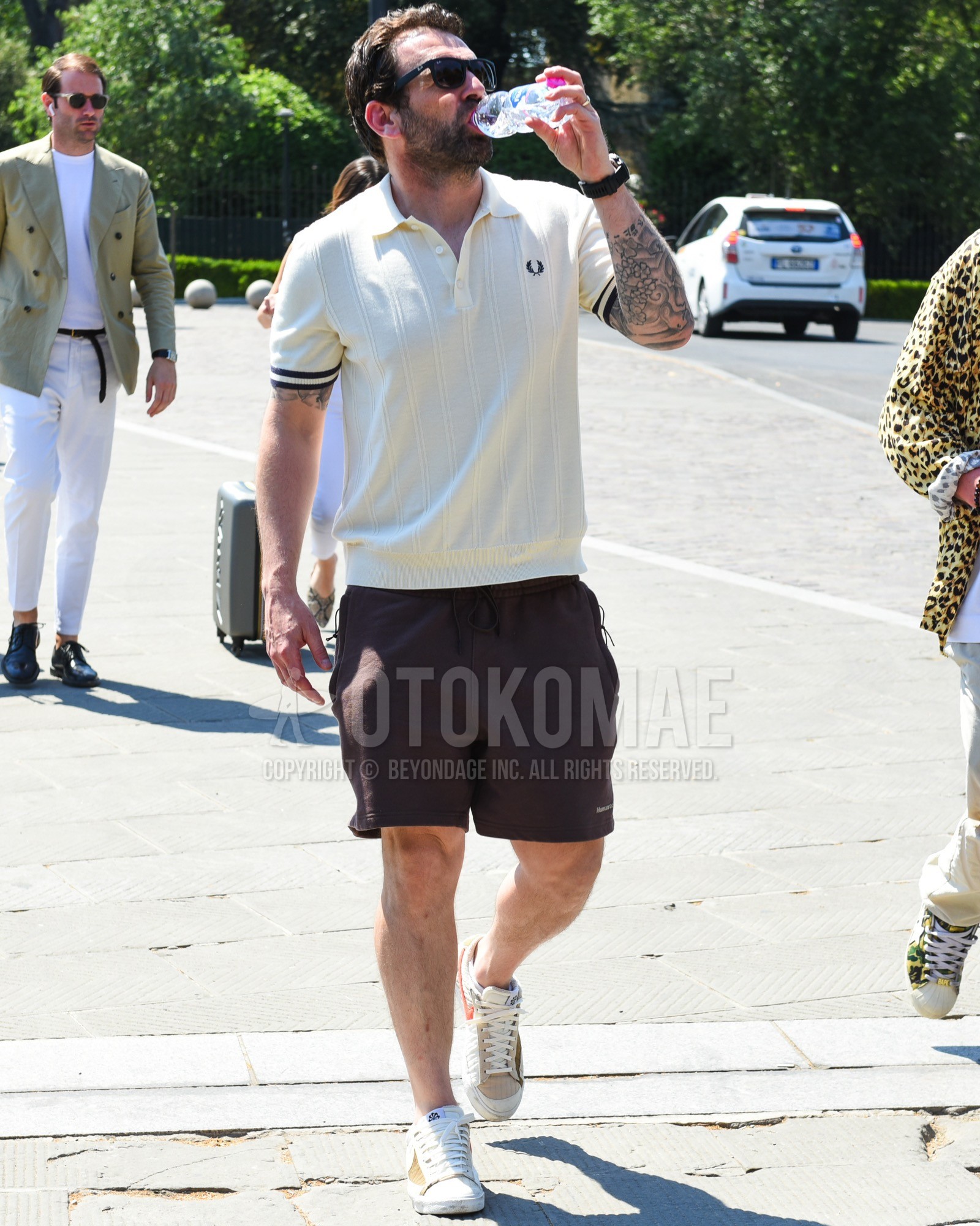 Men's spring summer outfit with black plain sunglasses, white plain polo shirt, brown plain short pants, beige white sneakers. | OTOKOMAE