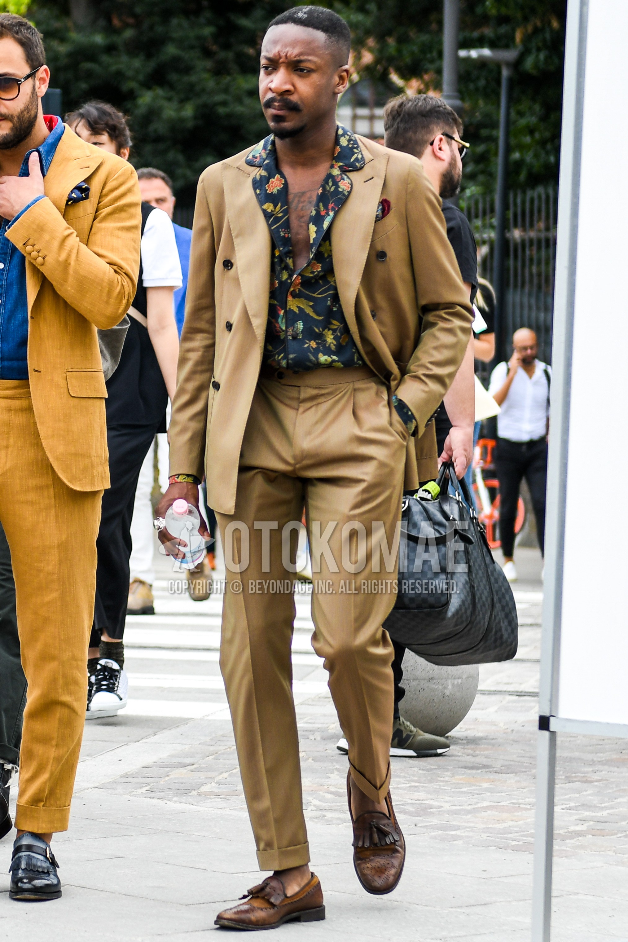 Men's spring summer autumn outfit with navy botanical shirt, brown tassel loafers leather shoes, beige plain suit.
