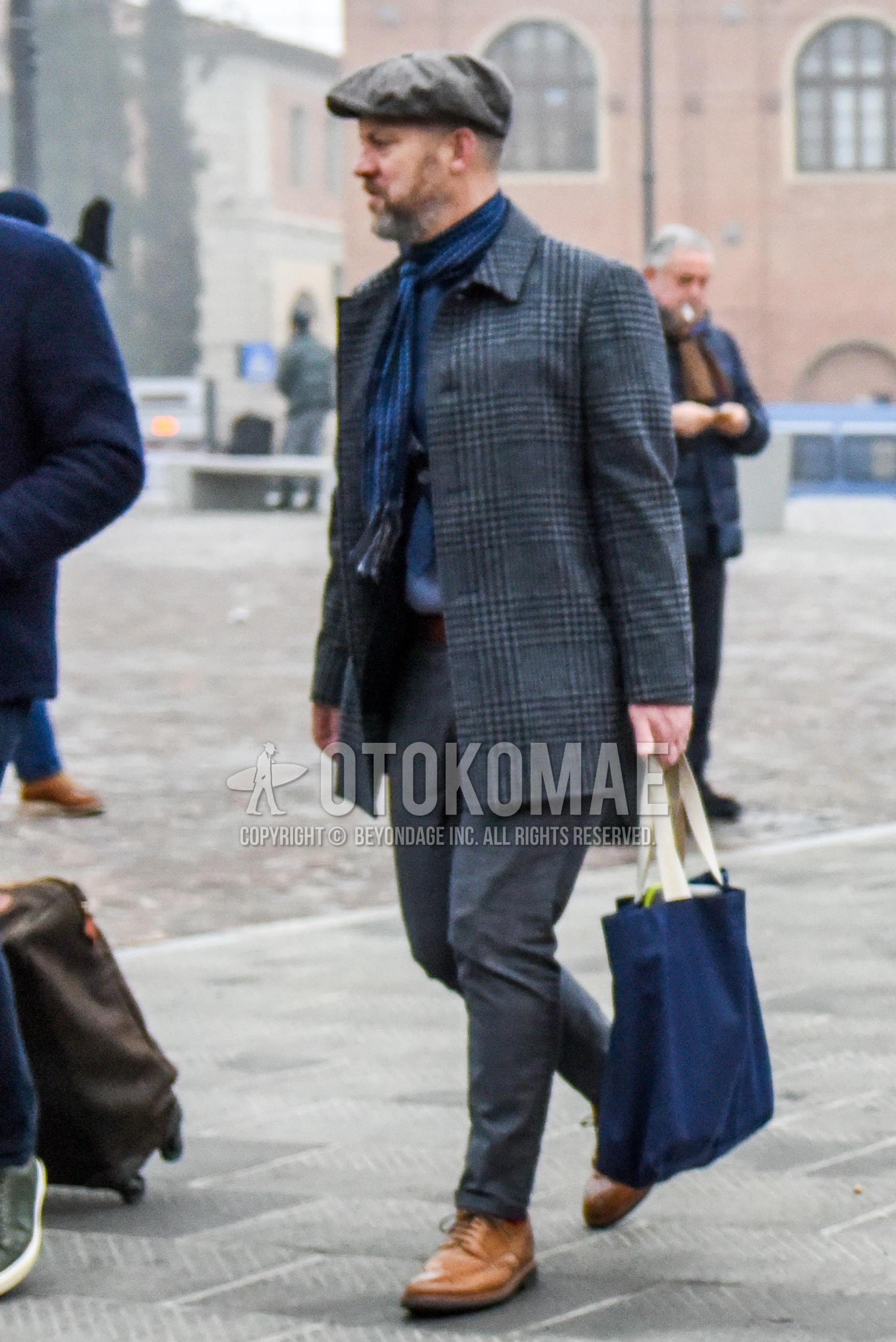 Men's winter outfit with gray plain cap, blue stripes scarf, gray check stenkarrer coat, gray plain slacks, brown wing-tip shoes leather shoes, navy plain tote bag.