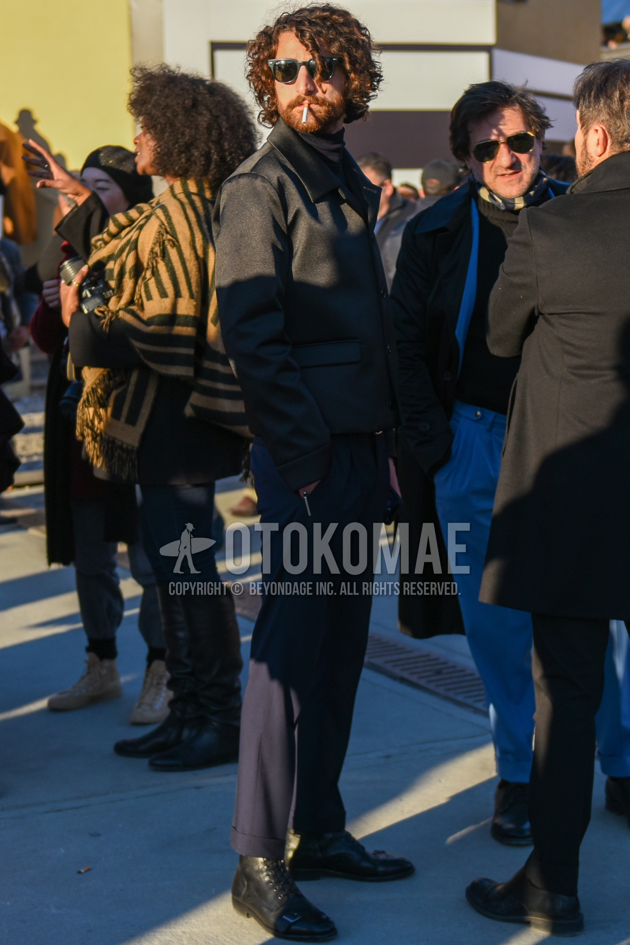 Men's autumn winter outfit with black plain sunglasses, black plain outerwear, black plain turtleneck knit, dark gray plain slacks, dark gray plain cropped pants, black  boots.