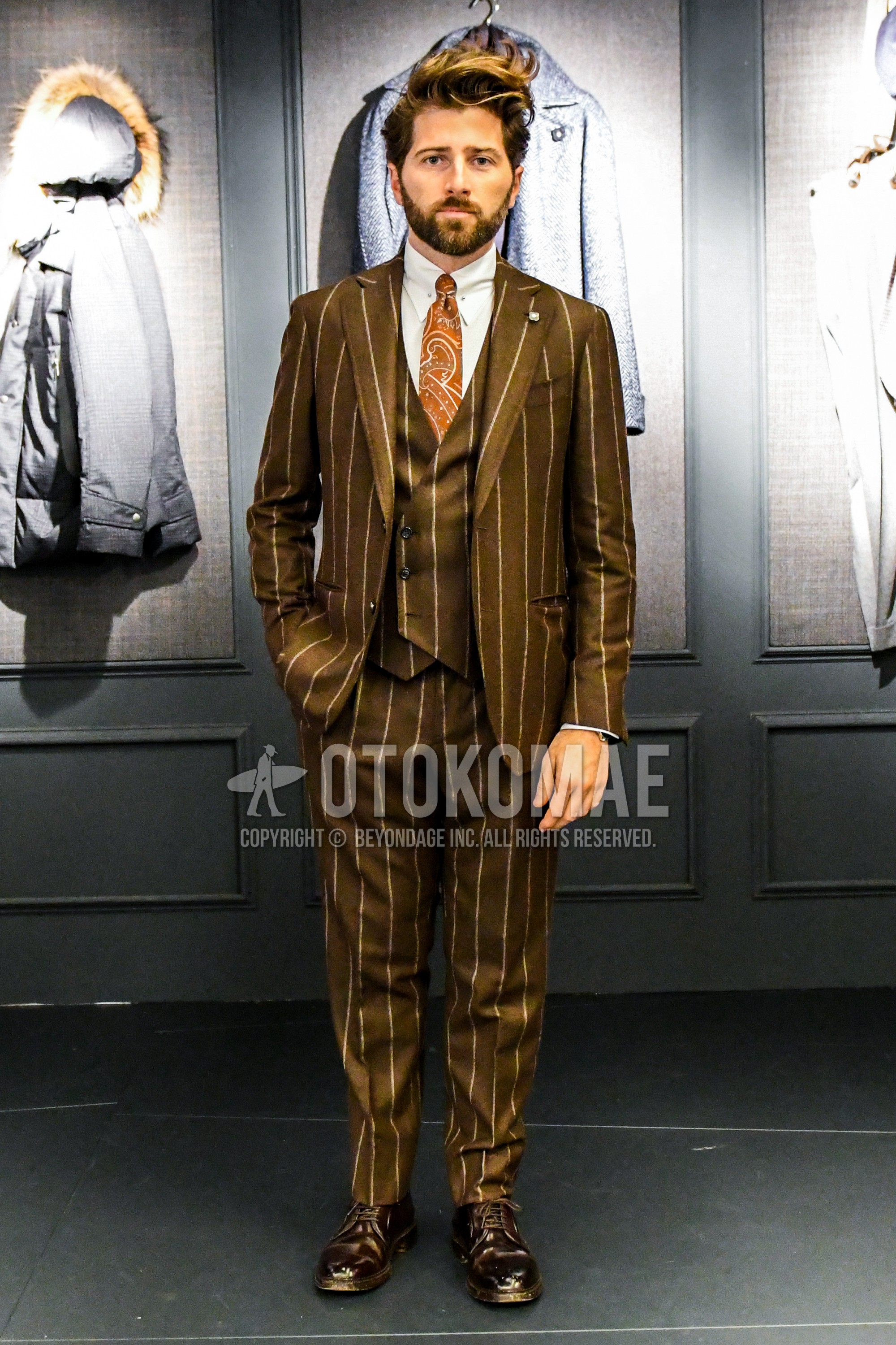 Men's winter outfit with white plain shirt, brown plain toe leather shoes, brown stripes three-piece suit, brown graphic necktie.