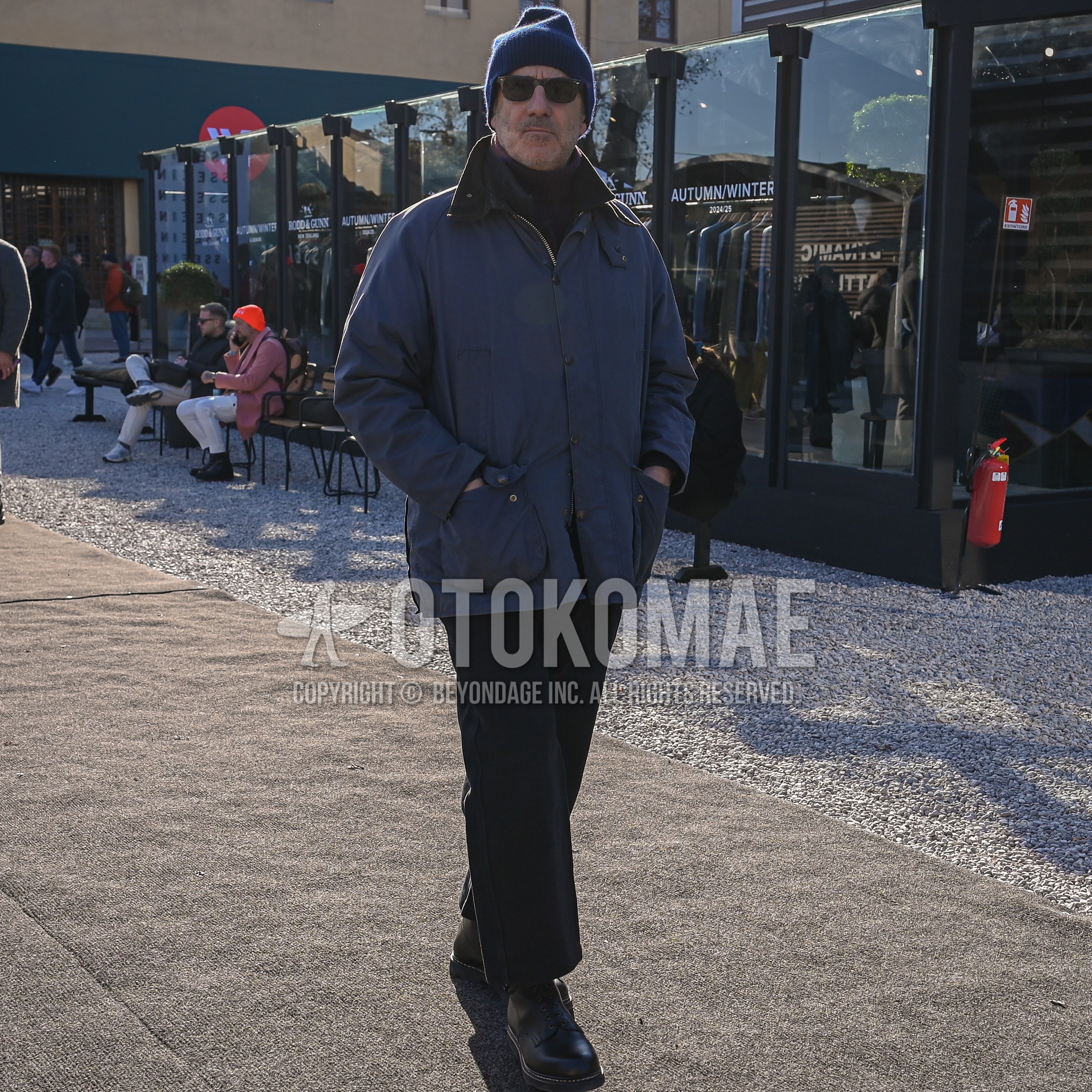 Men's autumn winter outfit with navy plain knit cap, dark gray plain sunglasses, navy outerwear field jacket/hunting jacket, black plain turtleneck knit, black plain slacks, black  boots.