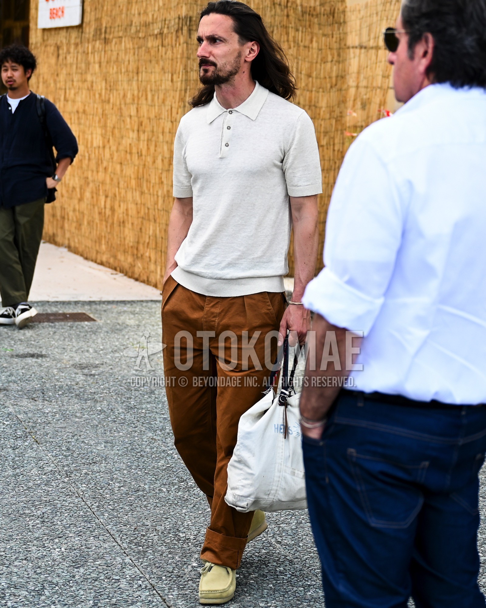 Men's spring summer outfit with white plain polo shirt, brown plain pleated pants, beige moccasins/deck shoes leather shoes.