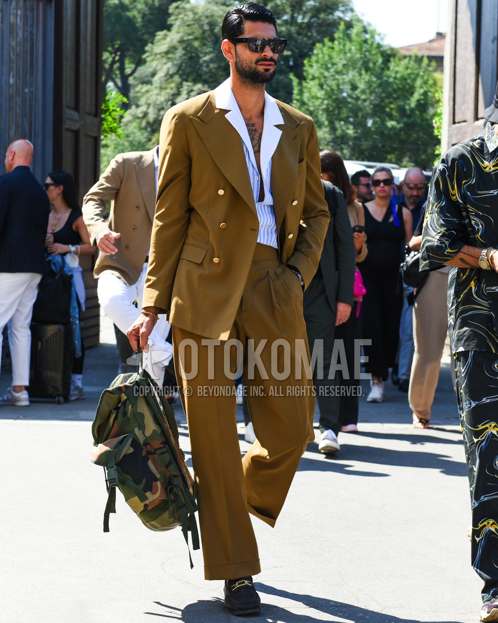Men's spring summer outfit with black plain sunglasses, white blue stripes shirt, black bit loafers leather shoes, olive green camouflage backpack, brown plain suit.