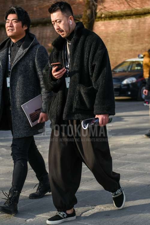 黒無地のフリースジャケット、黒無地のタートルネックニット、黒無地のジョガーパンツ/リブパンツ、黒スリッポンのスニーカーを合わせた秋冬のメンズコーデ・着こなし。