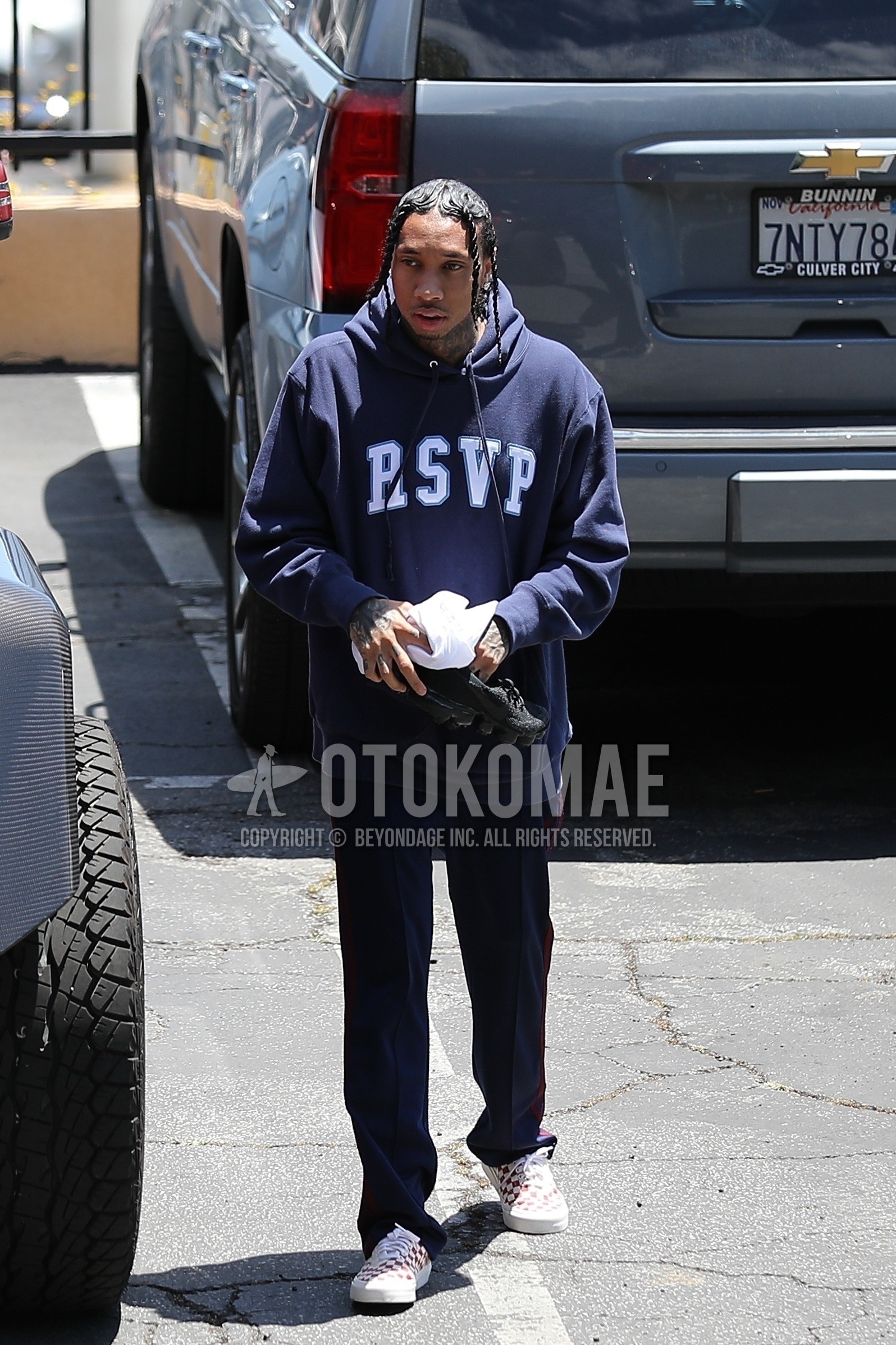 Men's spring summer outfit with navy graphic hoodie, navy plain sideline pants, white low-cut sneakers.