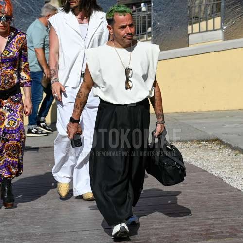 黒無地のメガネ、白無地のTシャツ、黒無地のレザーベルト、黒無地のスラックス、黒無地のプリーツパンツ、黒無地のワイドパンツ、白ローカットのスニーカー、黒無地のバッグを合わせた春夏のメンズコーデ・着こなし。