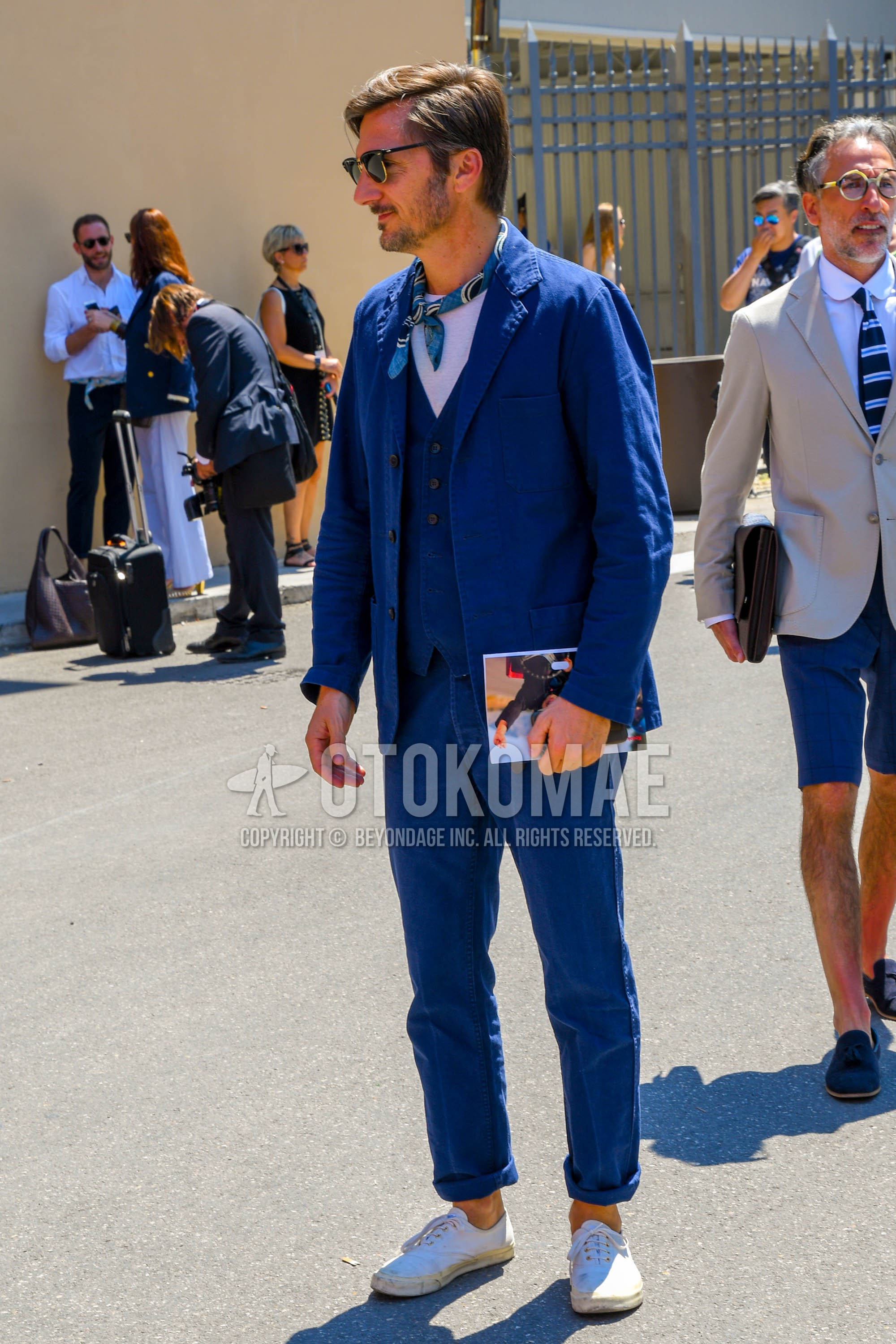 Men's spring summer autumn outfit with plain sunglasses, light blue blue scarf bandana/neckerchief, white plain t-shirt, white low-cut sneakers, blue plain three-piece suit.