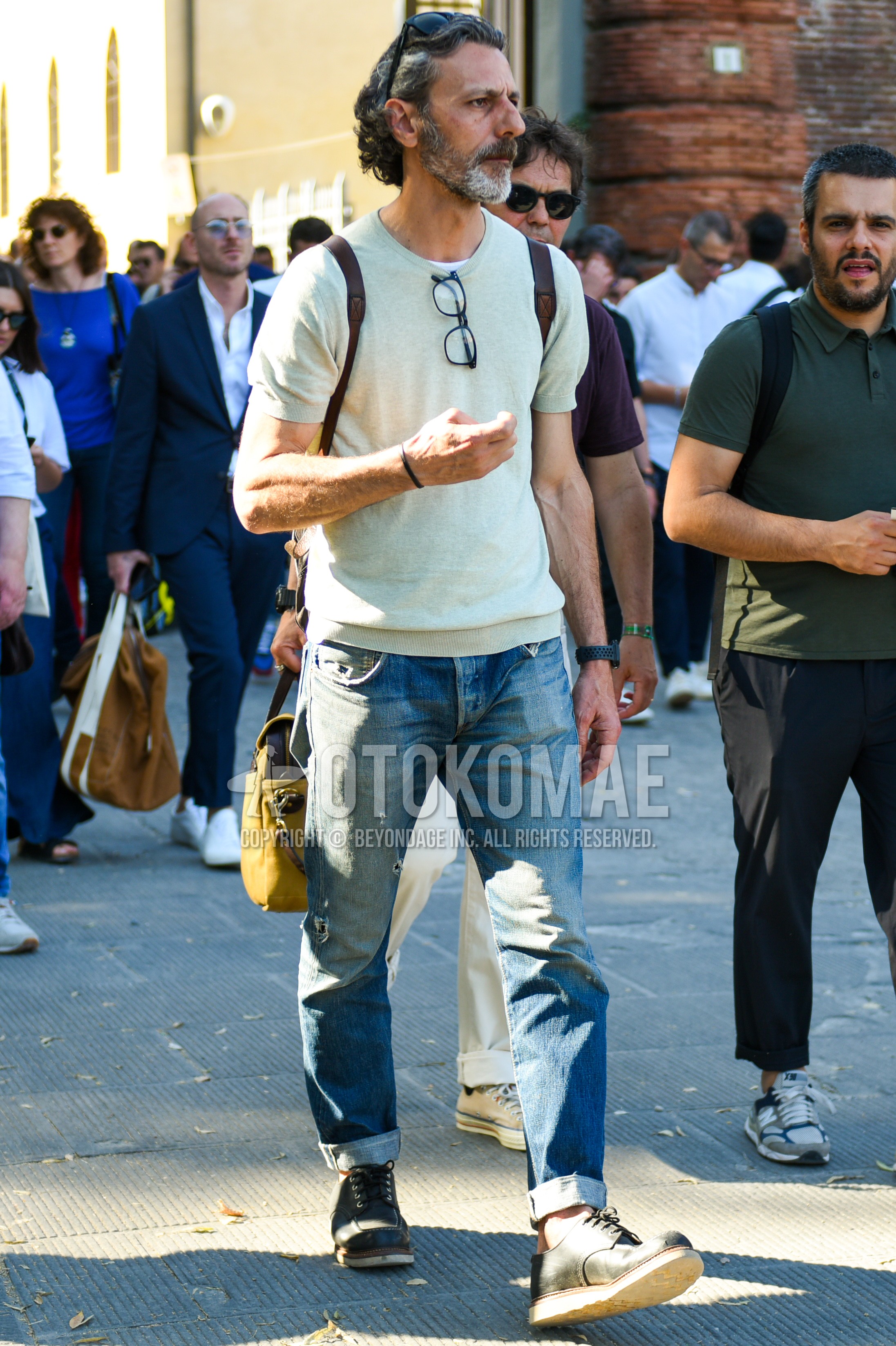 Men's summer outfit with beige plain t-shirt, blue plain denim/jeans, black work boots.