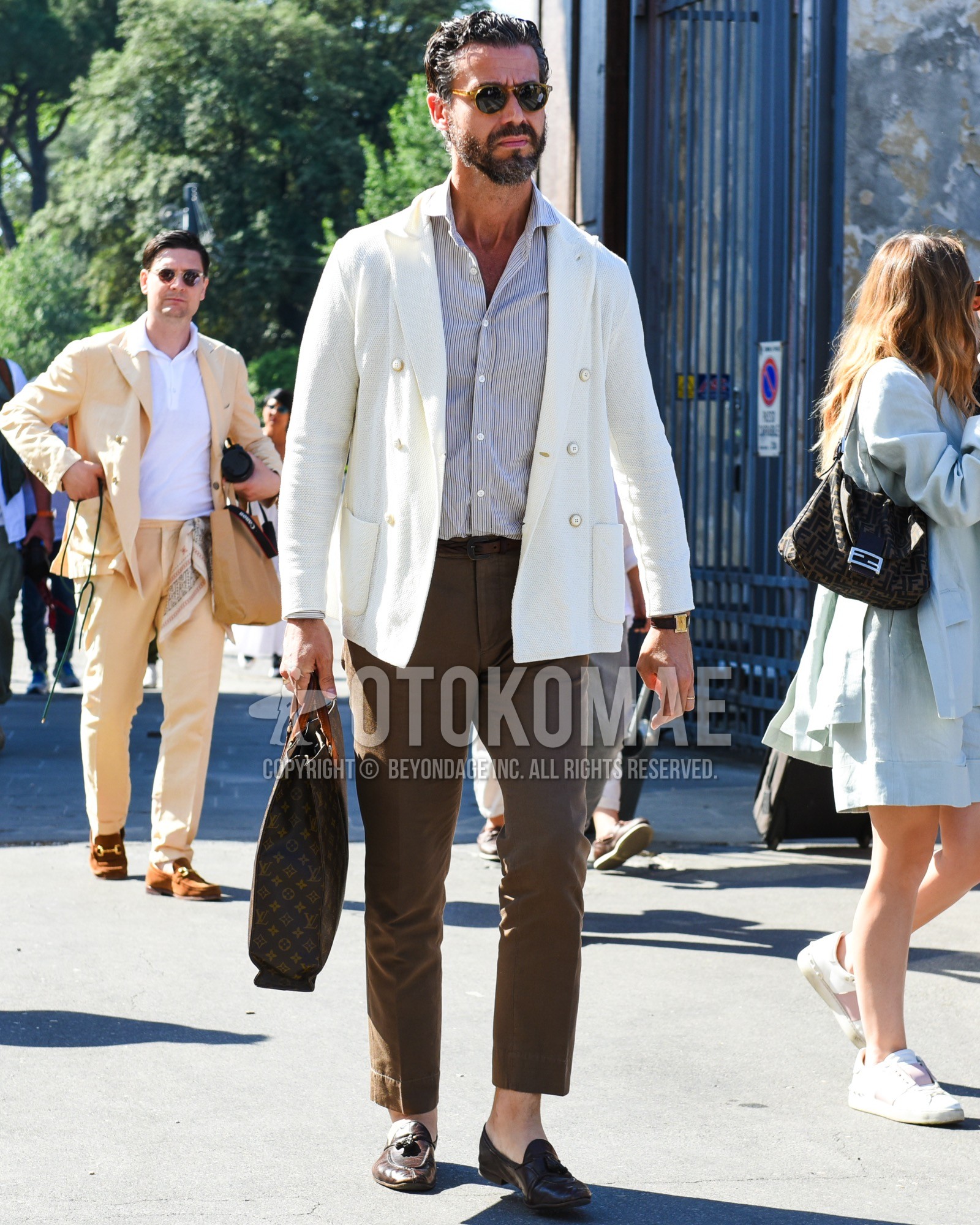 Men's spring summer outfit with brown tortoiseshell sunglasses, white plain tailored jacket, blue stripes shirt, brown plain leather belt, brown plain slacks, brown plain cropped pants, brown tassel loafers leather shoes, brown check briefcase/handbag.