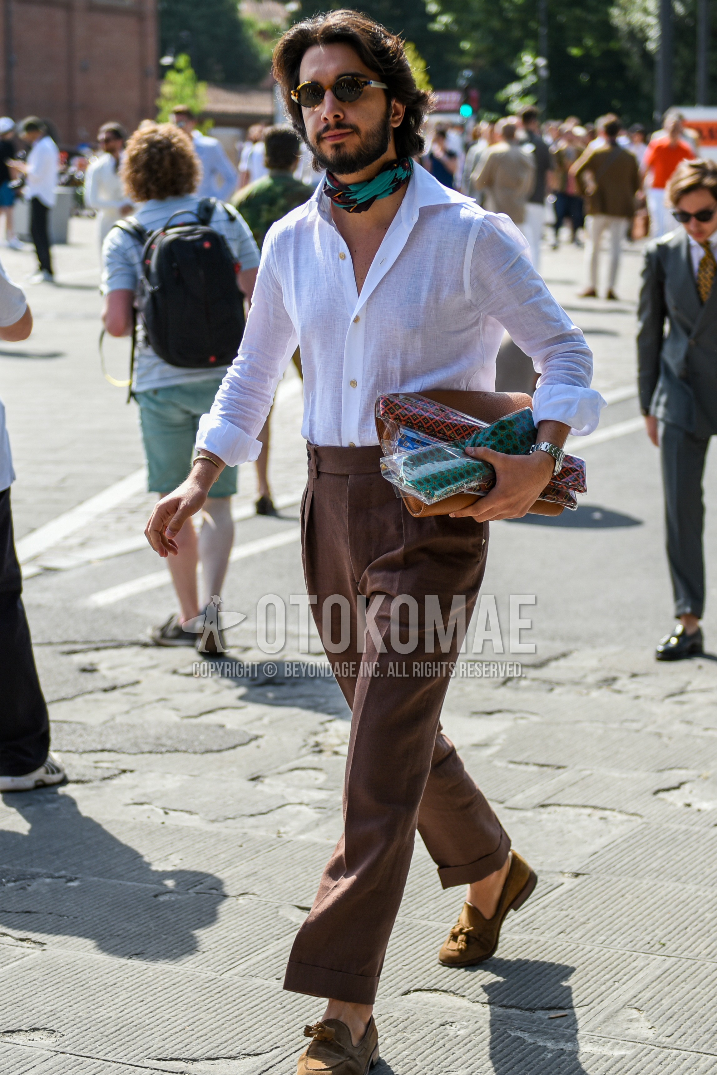 Men's spring summer outfit with brown tortoiseshell sunglasses, white plain shirt, brown plain slacks.