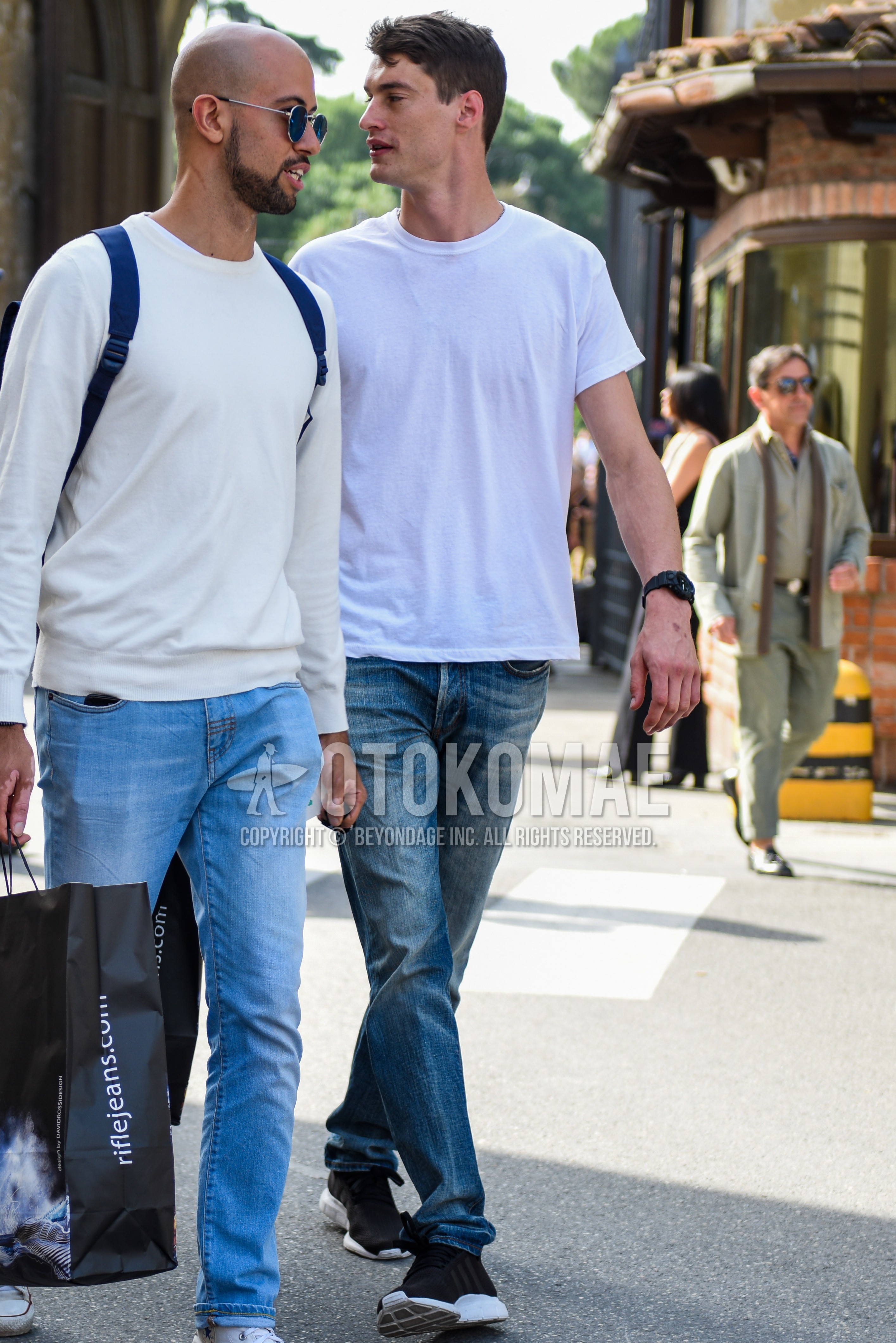 Men's summer outfit with white plain t-shirt, blue plain denim/jeans, black low-cut sneakers.