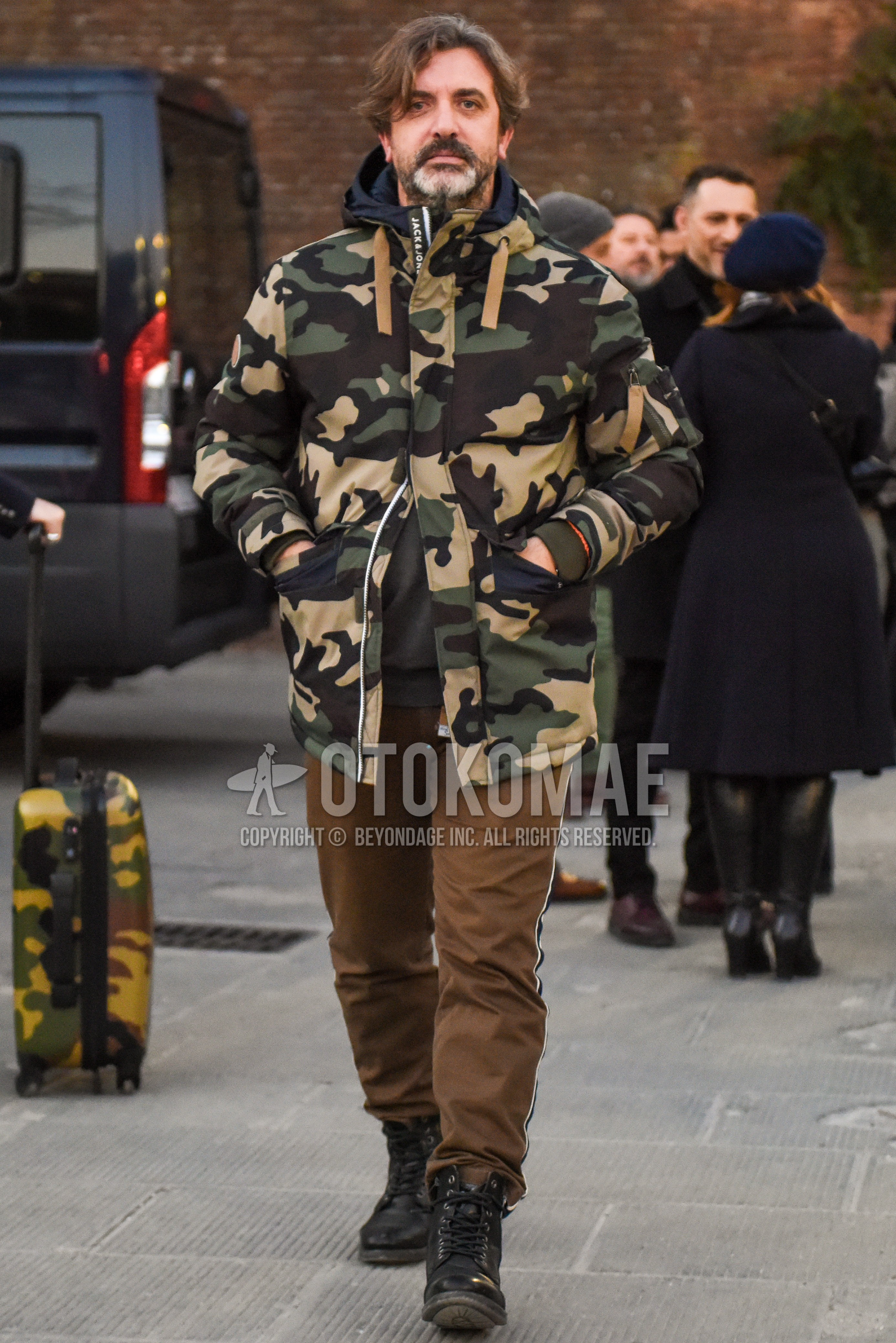 Men's autumn winter outfit with olive green beige camouflage hooded coat, beige plain sideline pants, black  boots.