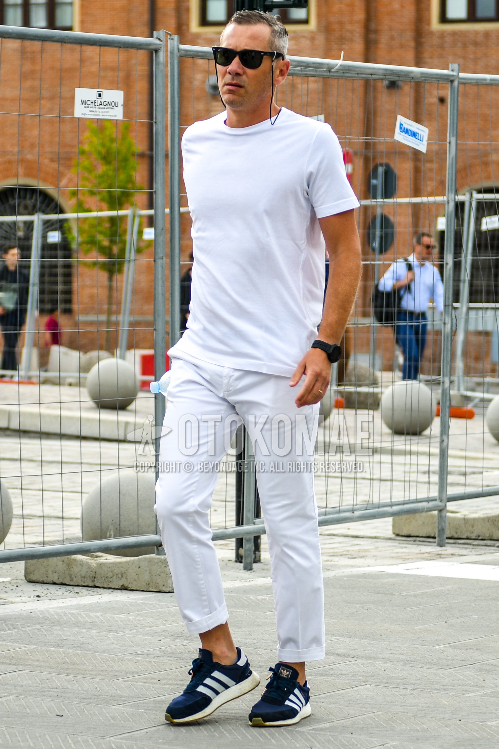 Men's summer outfit with plain sunglasses, white plain t-shirt, white plain denim/jeans, navy low-cut sneakers.