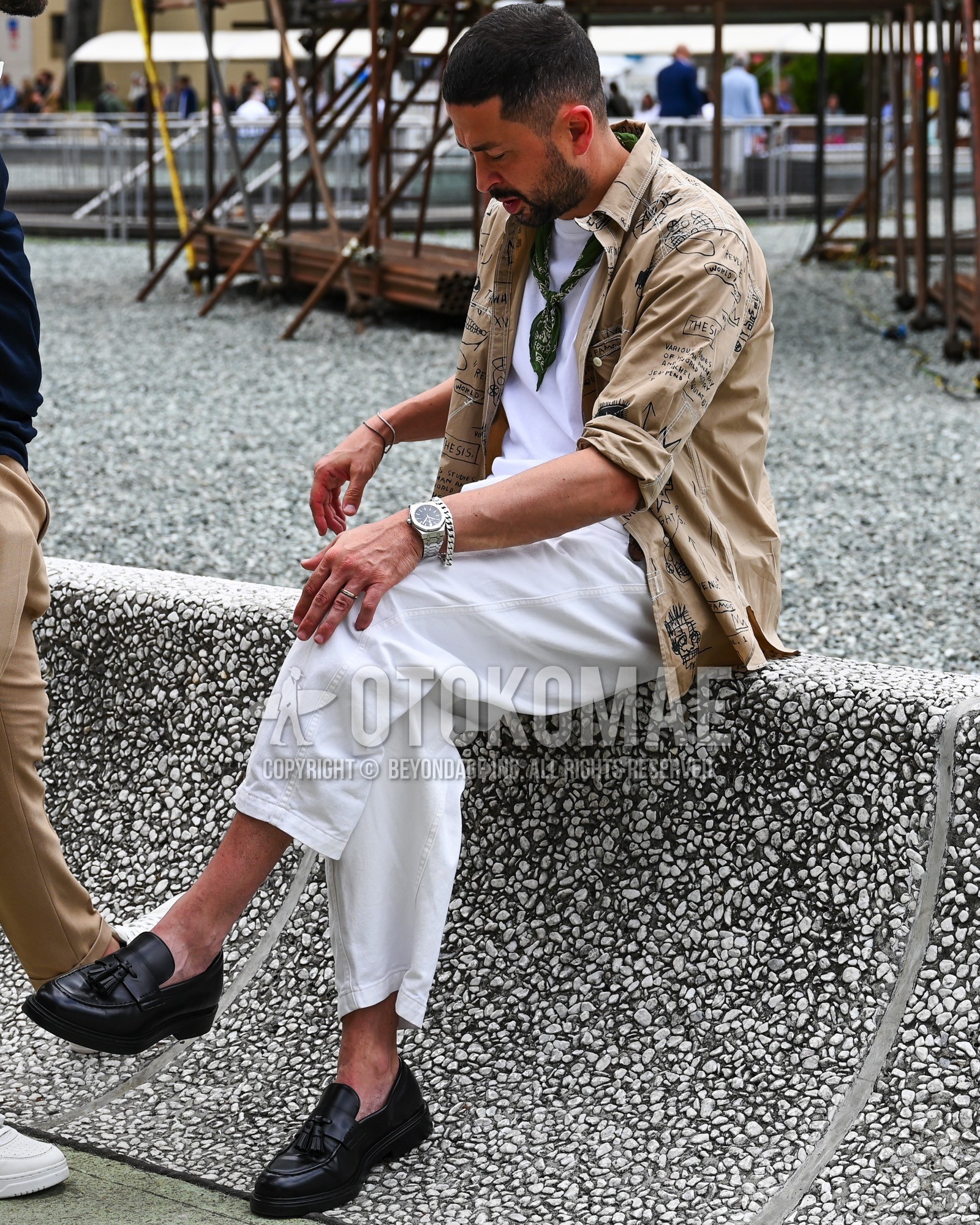 Men's spring summer autumn outfit with black whole pattern bandana/neckerchief, beige whole pattern outerwear, white plain t-shirt, white plain chinos, black tassel loafers leather shoes.
