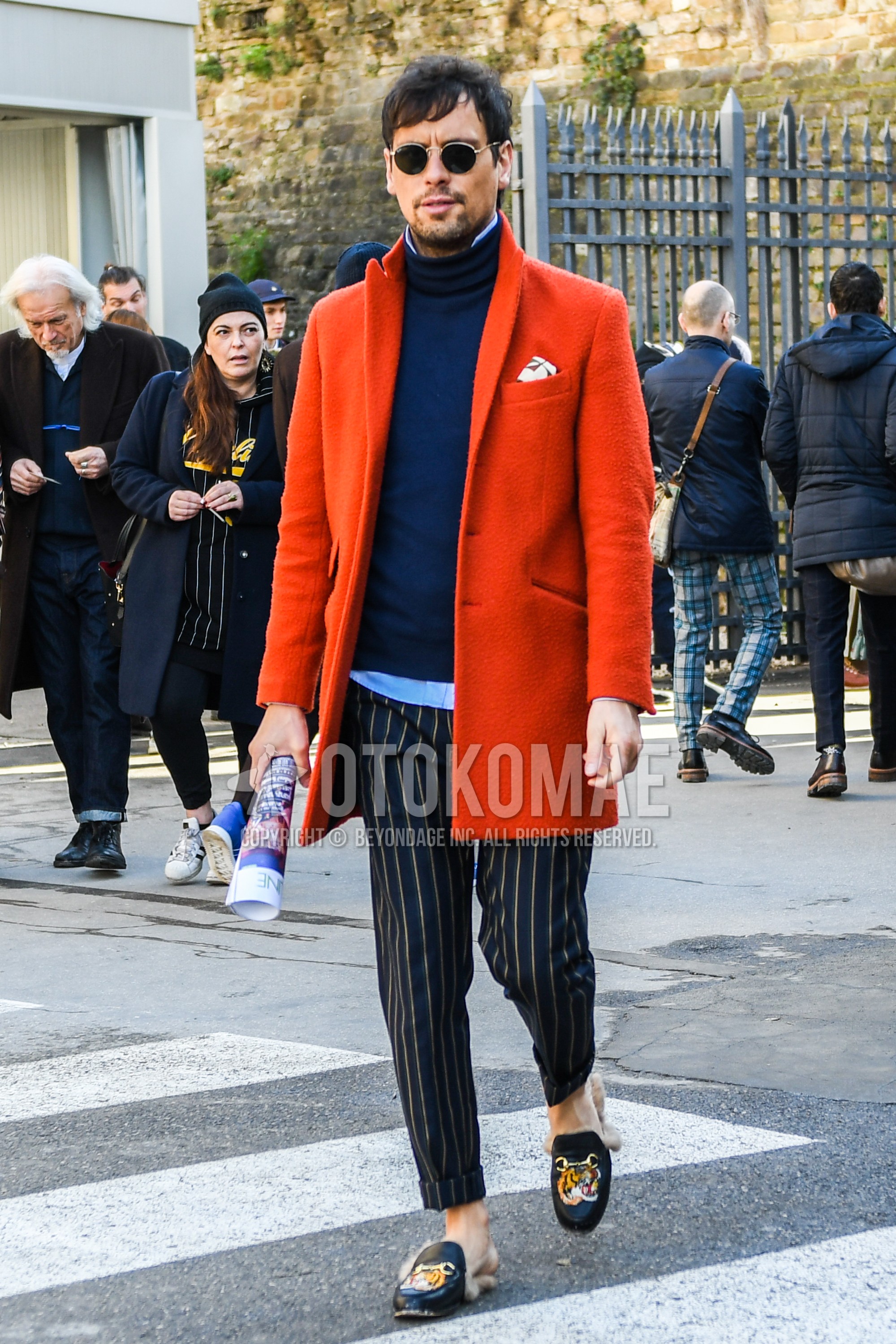 Men's winter outfit with plain sunglasses, red plain chester coat, navy plain turtleneck knit, navy stripes slacks, black bit loafers leather shoes.