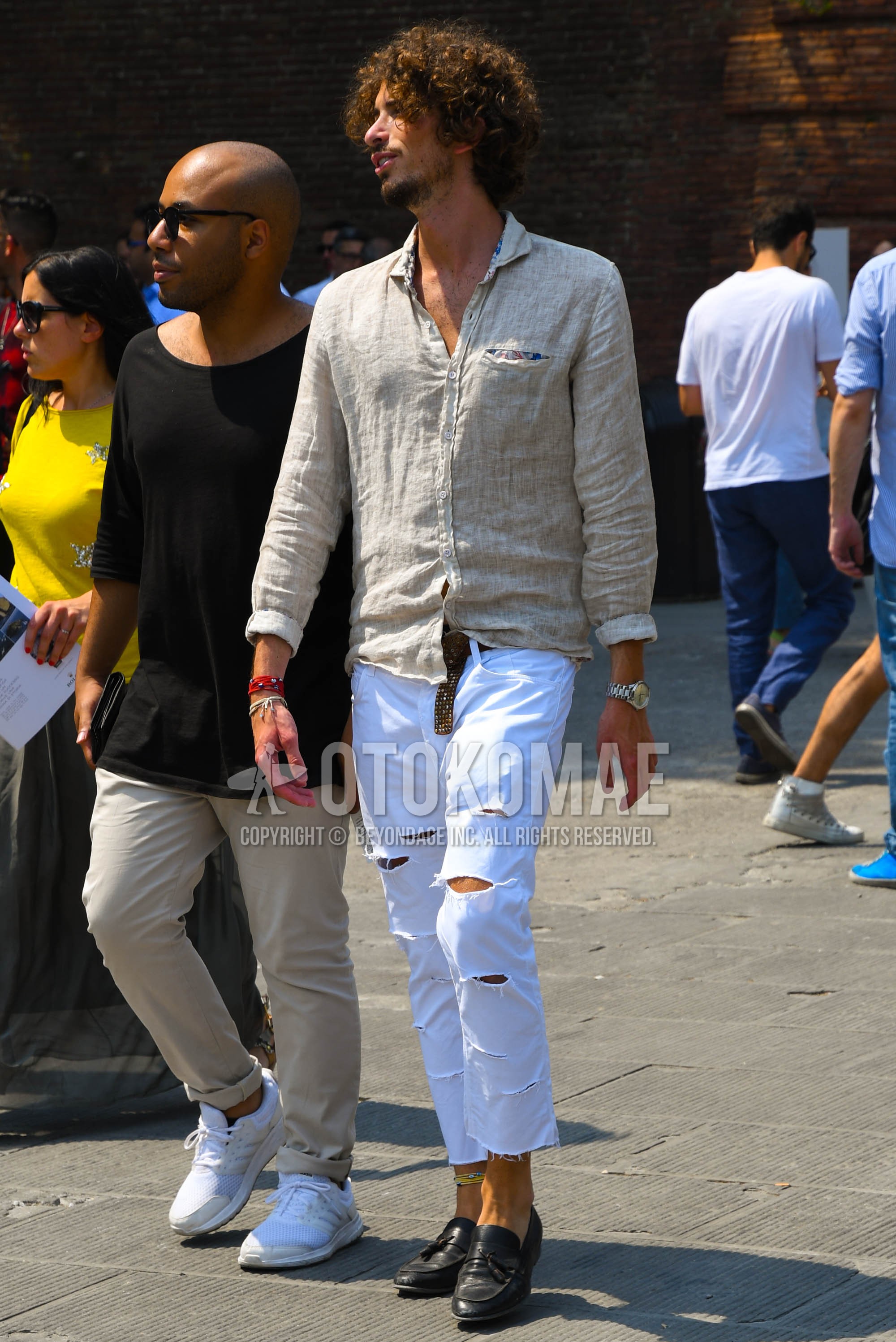 Men's spring summer outfit with beige plain shirt, white plain damaged jeans, black tassel loafers leather shoes.